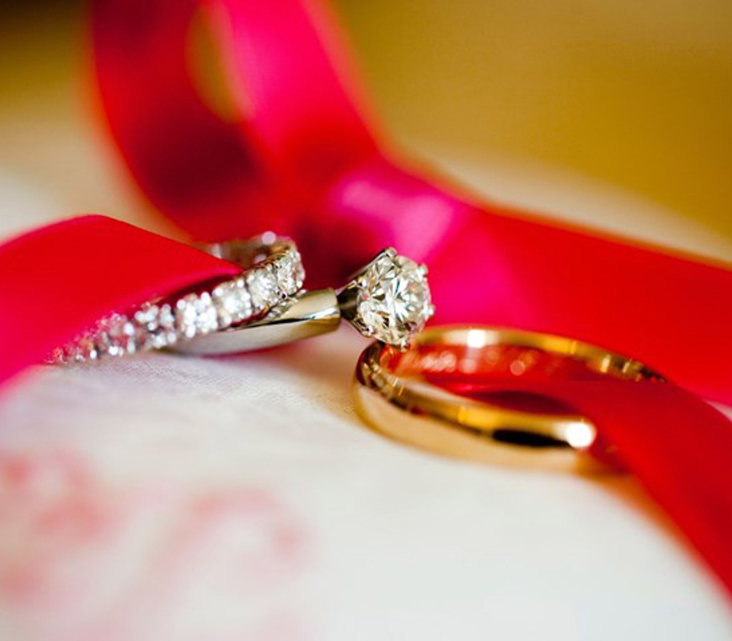 Bröllopsringar lindade med ett rött band 
