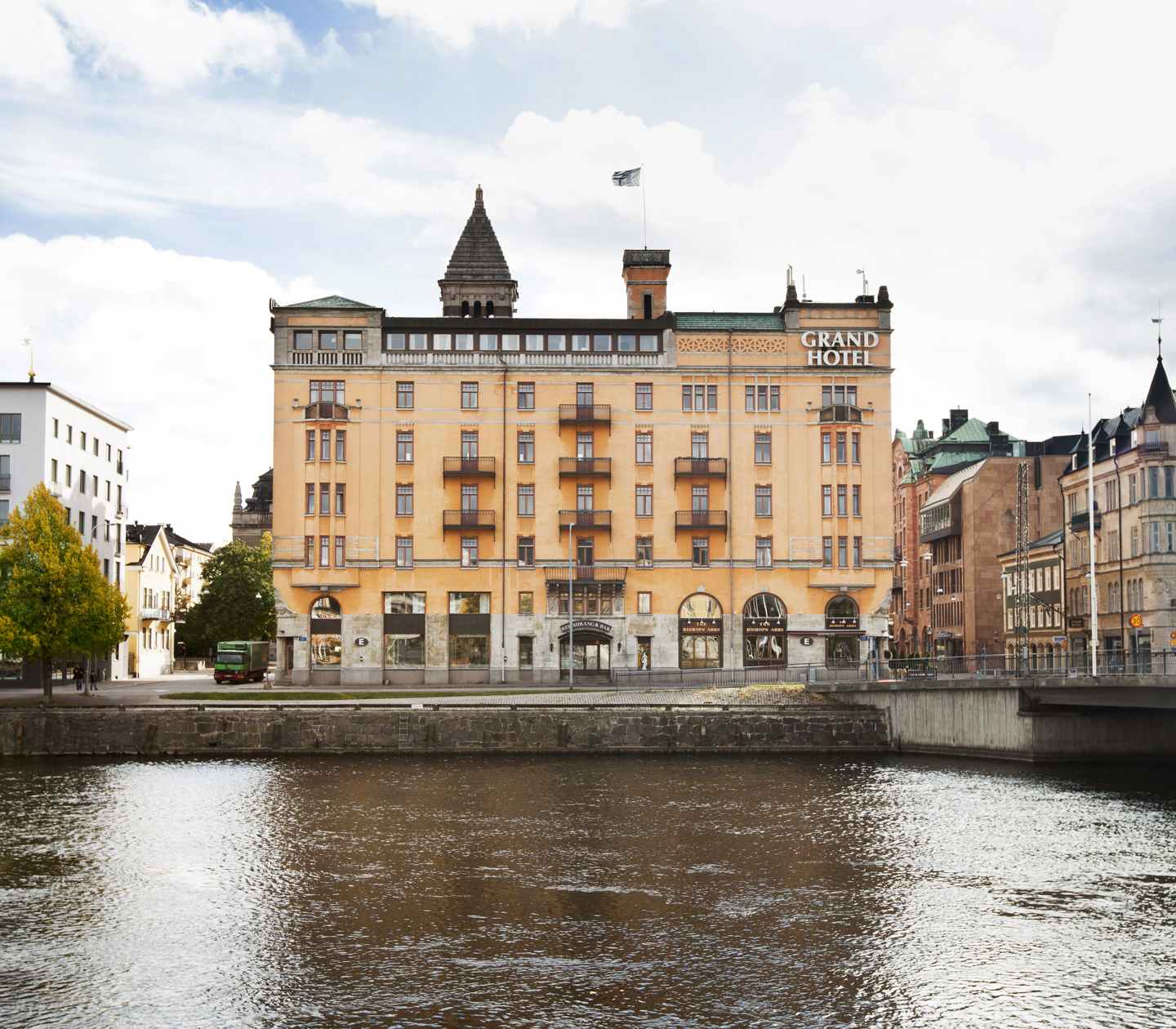 Orange fasaden av Elite Grand Hotel i Norrköping med Motala Ström framför