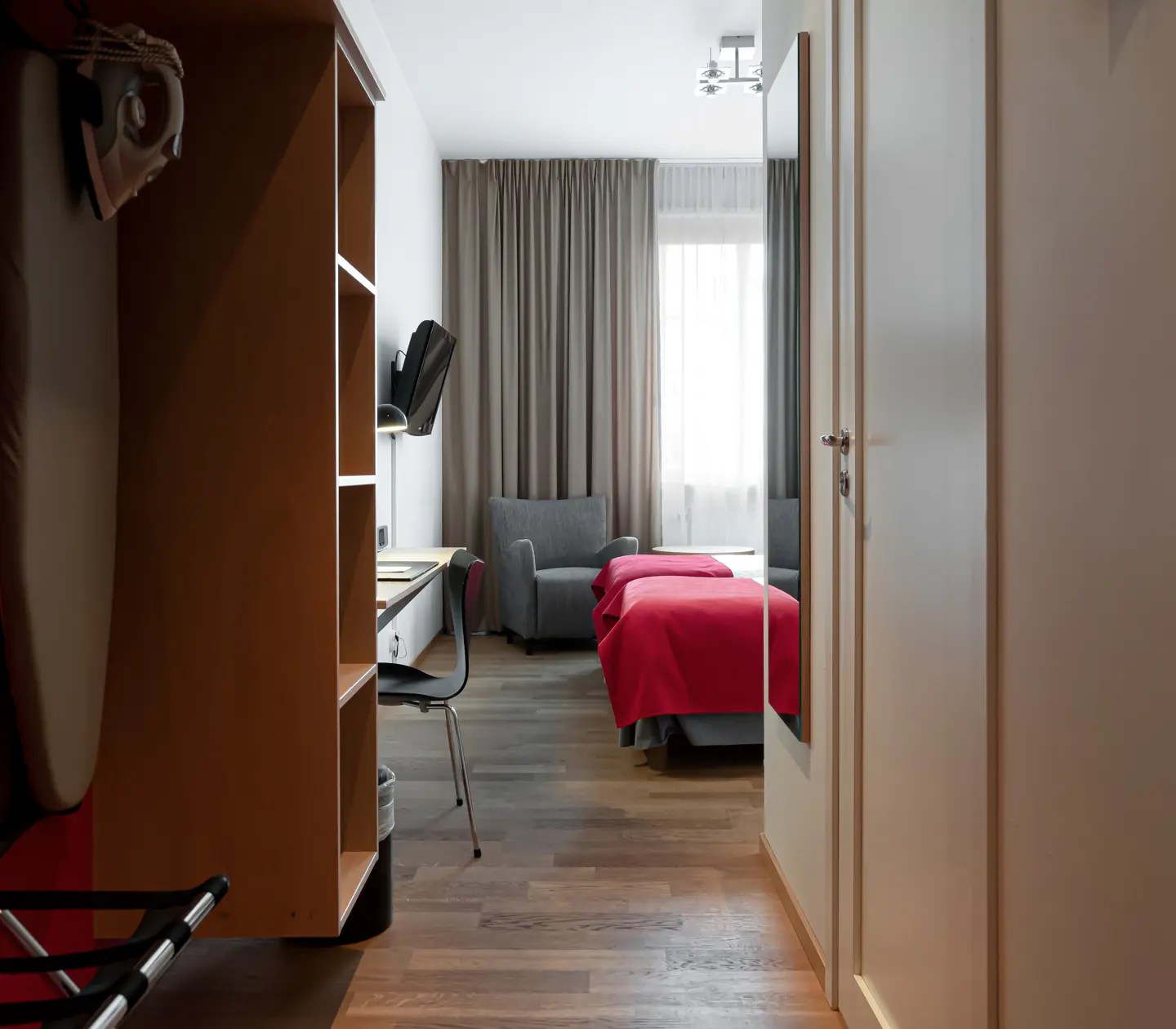 Hotellrum med skrivbord, fåtölj och tv