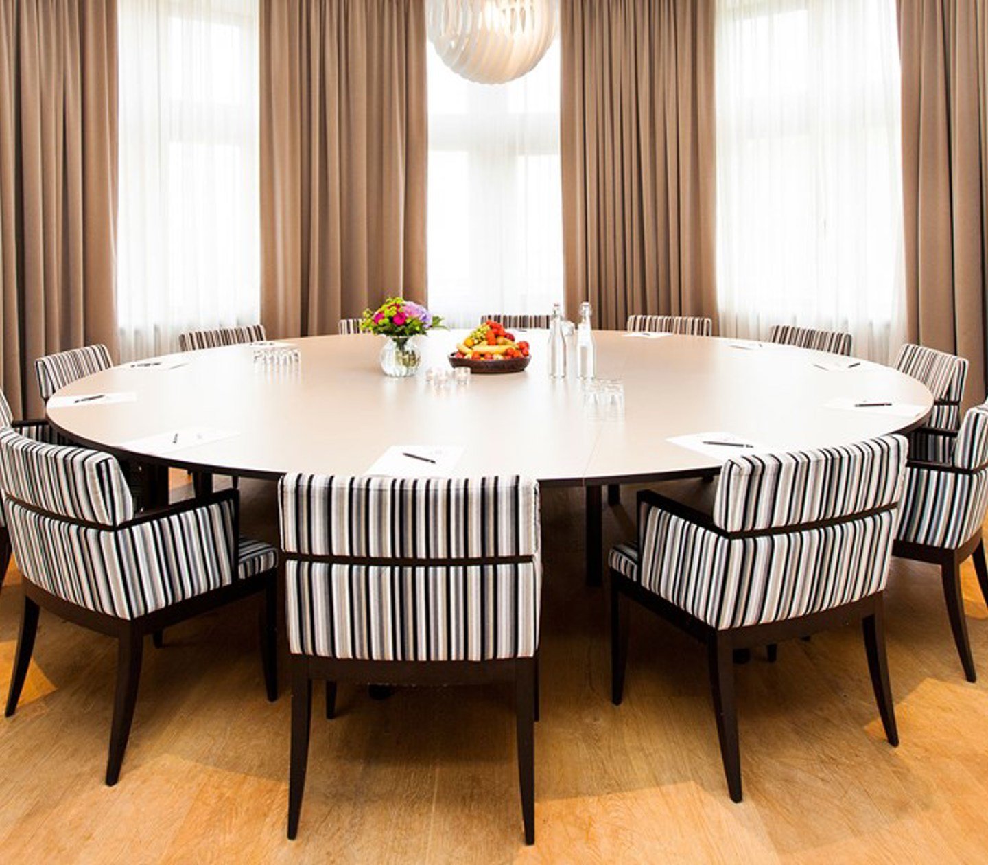 Conference room with round table, striped chairs and large windows