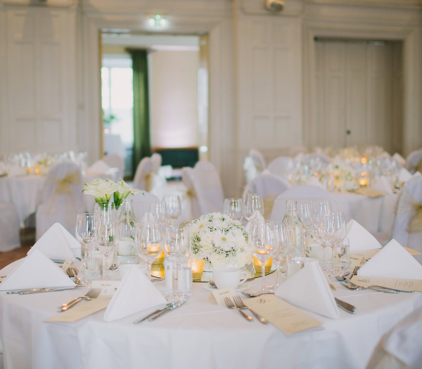 Table with white tablecloths in banquet hall