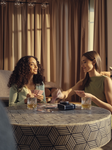 Two women playing cards in hotel room