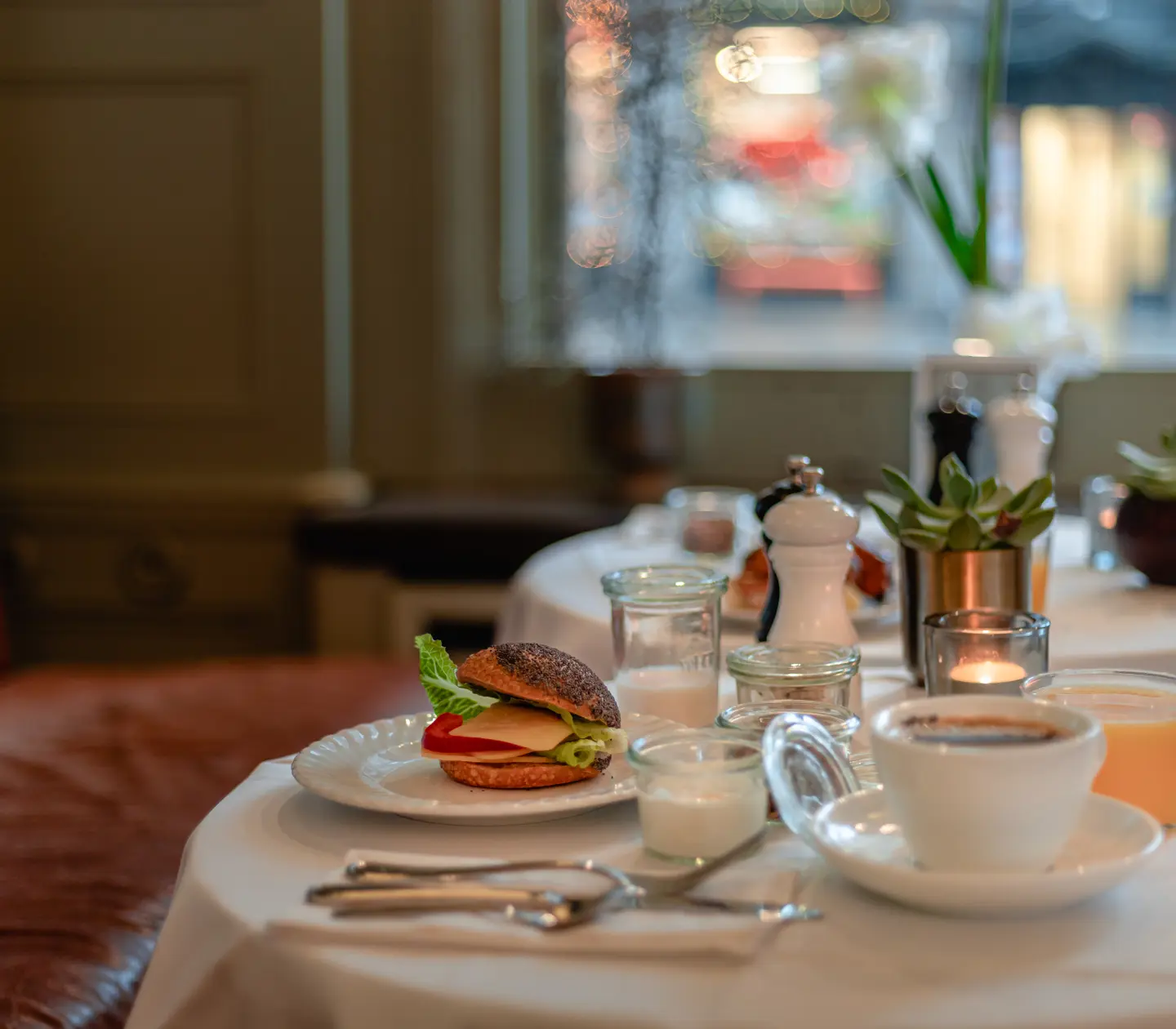 Frukost serverad på bord med kaffe, smörgås och juice