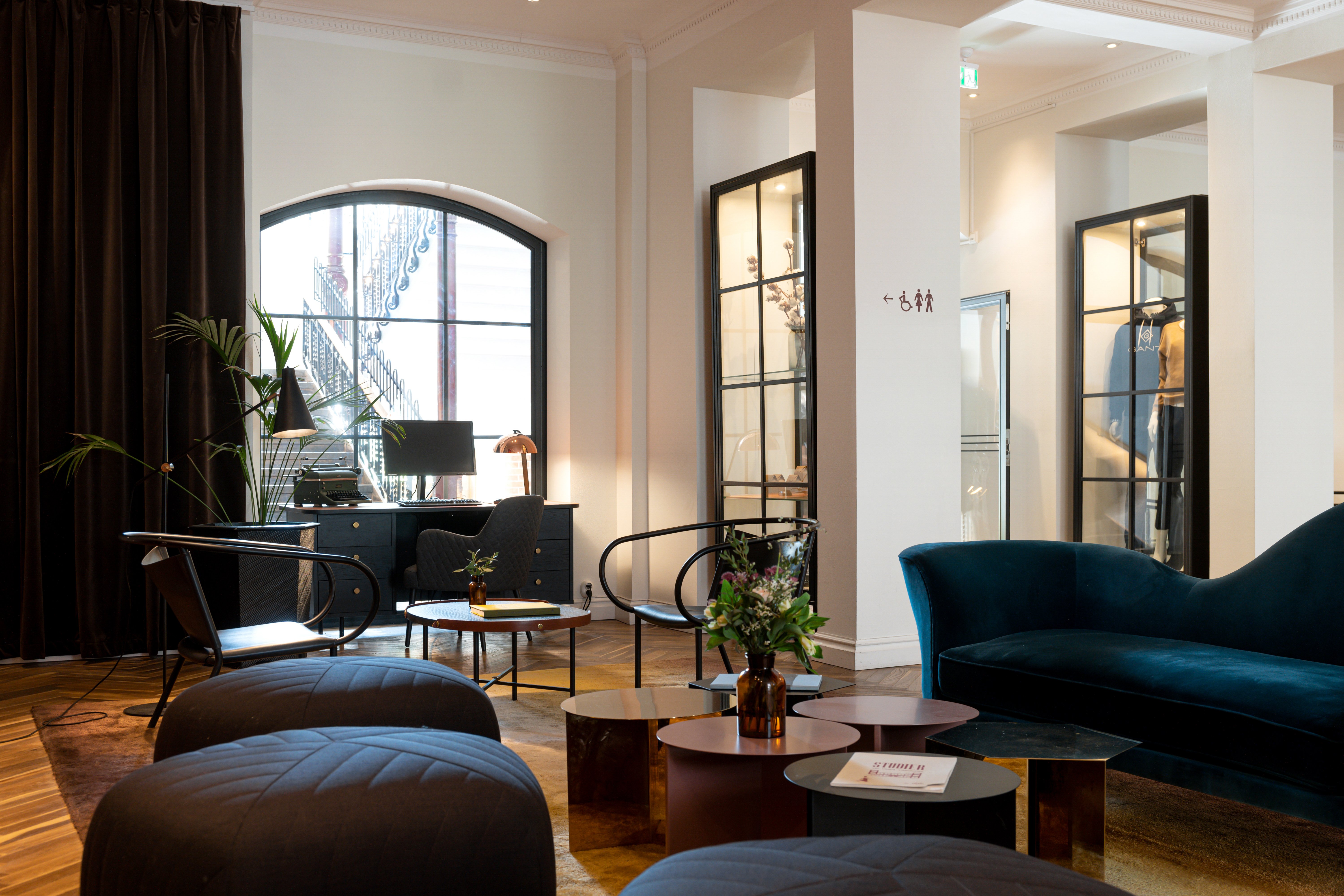 Matsal med många fönster, dekorationer och dukade runda bord