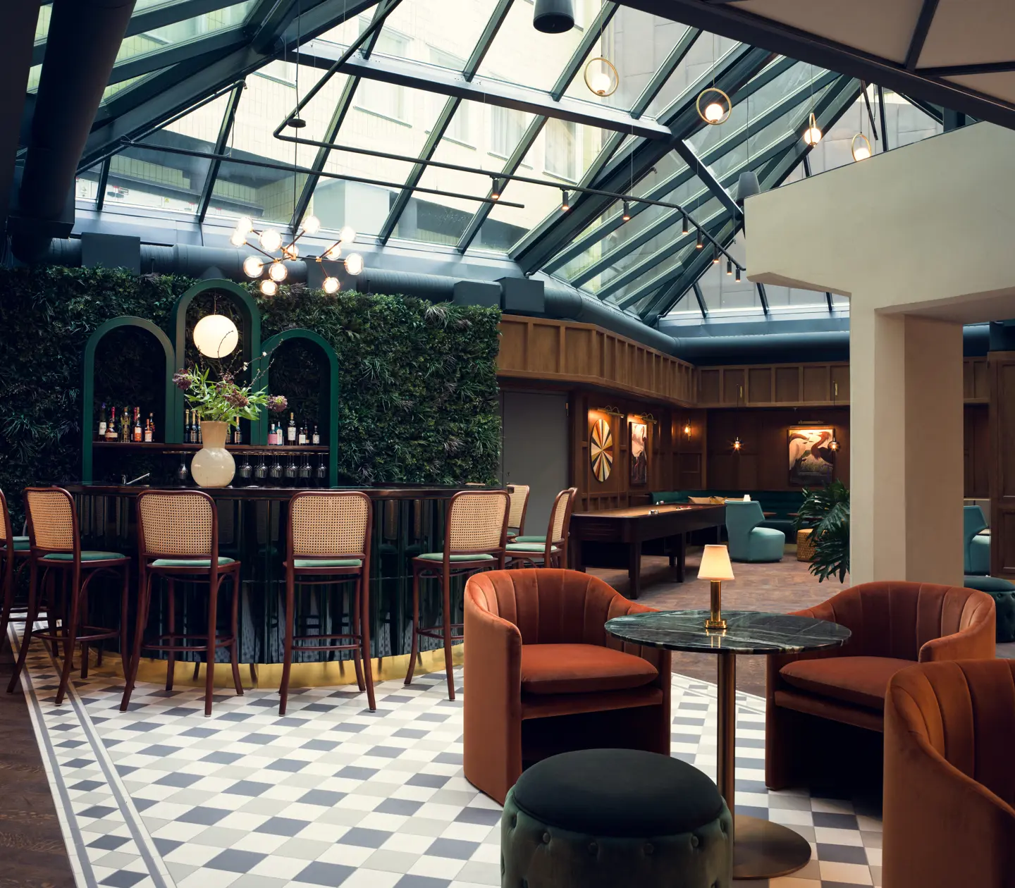 Elegant lounge with a bar and relaxation areas under a glass roof