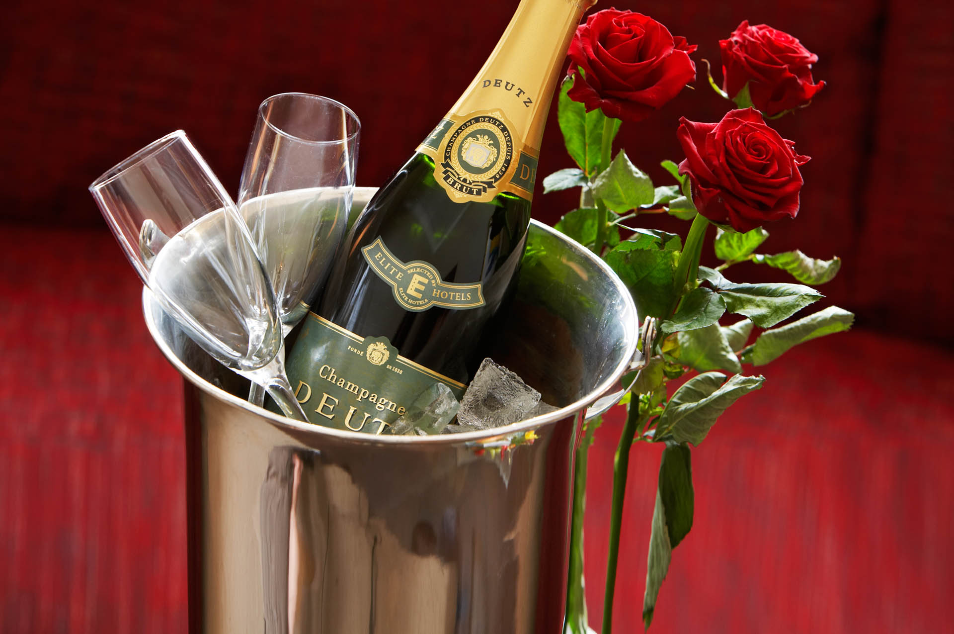 Champagne flaska med rosor och glas.