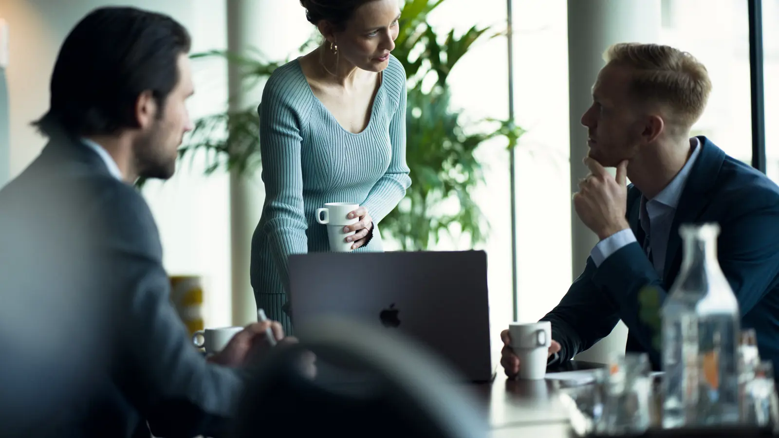 Armar som lutar på konferensbord med dator
