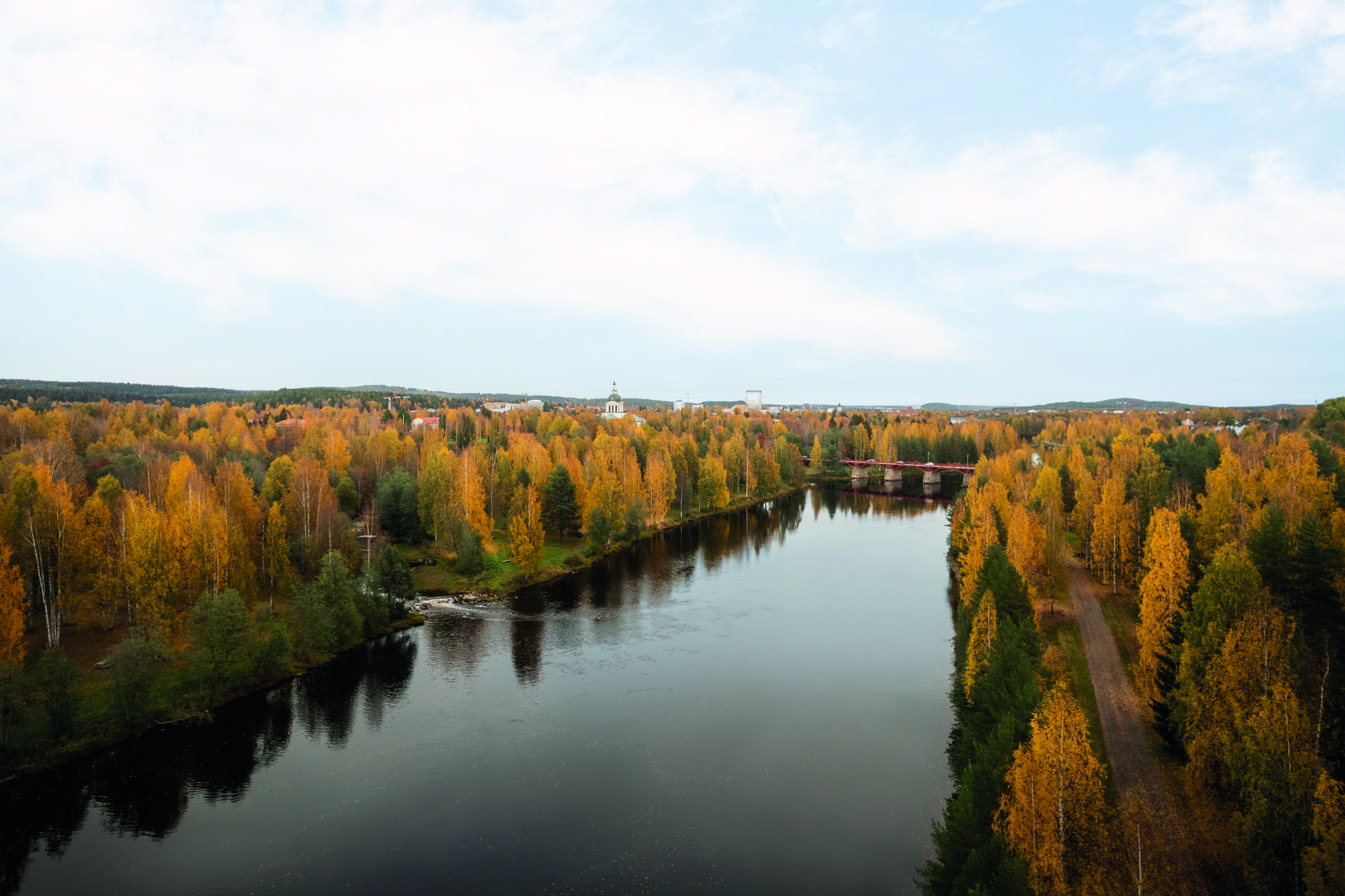 Utomhuspool med ånga över vattenytan, glasräcke och utsikt över Skellefteå.