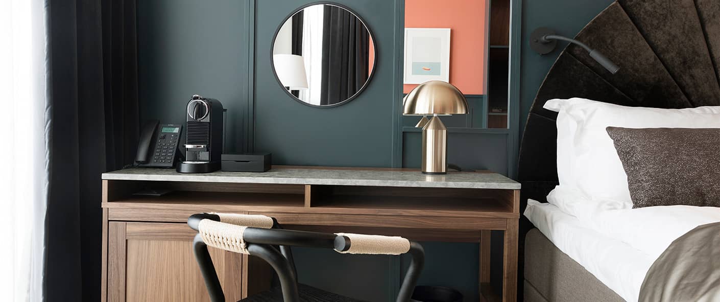 Vackert inrett hotellrum med en säng och ett skrivbord