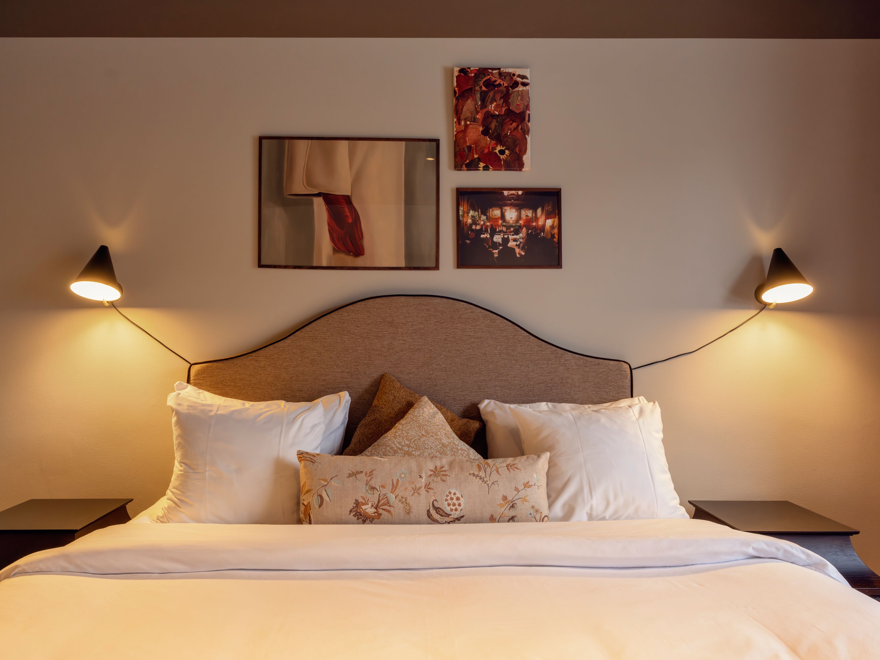 Ljust hotellrum med säng, skrivbord och tv