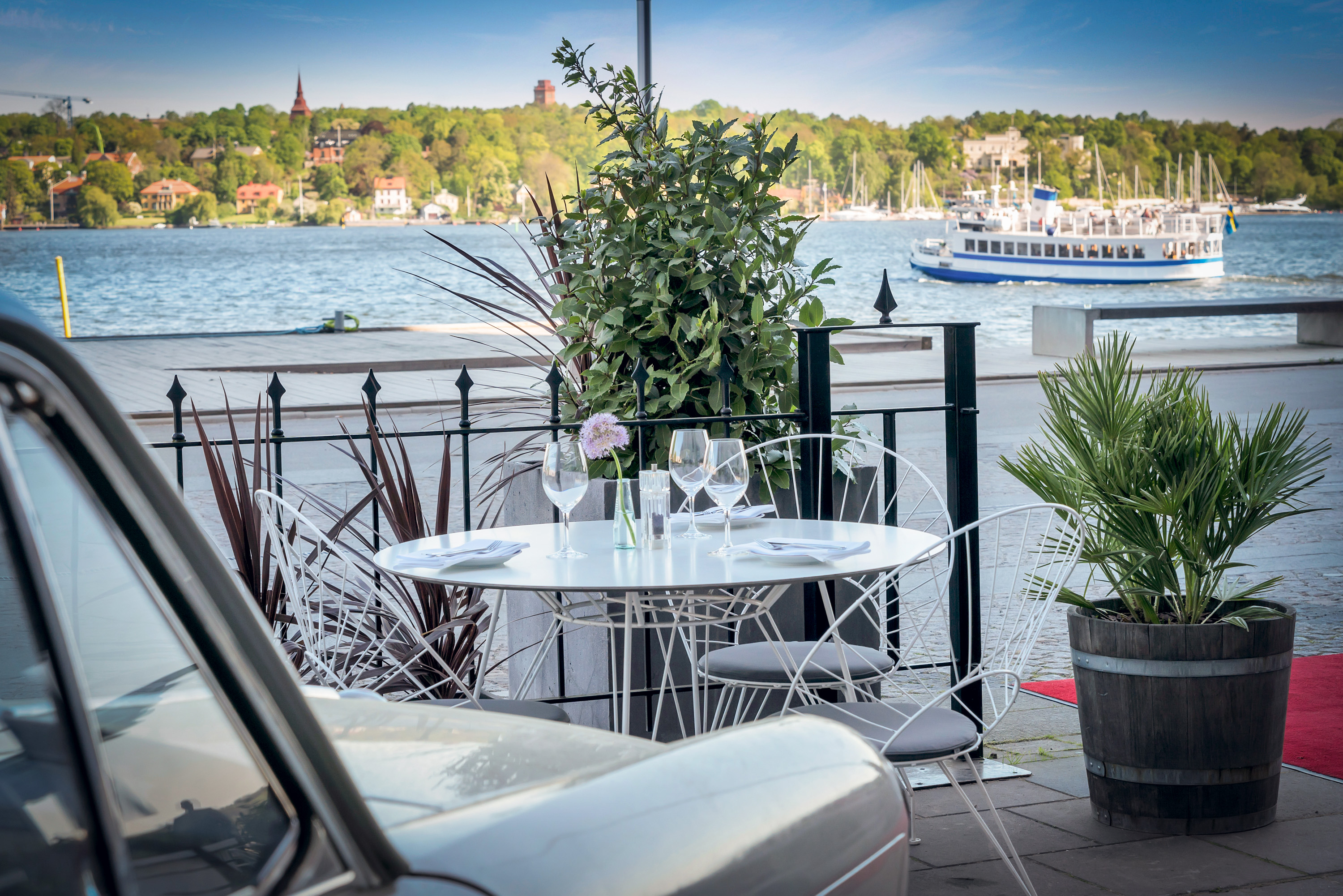 Vy över vattnet, park, och historiska byggnader i Stockholm.