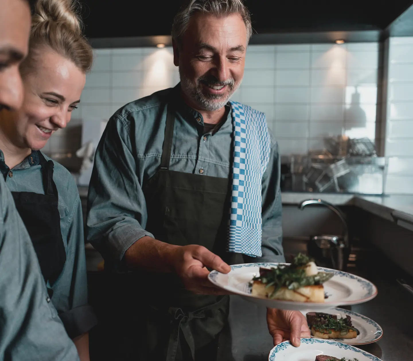 Kockar i ett restaurangkök förbereder och serverar maträtter