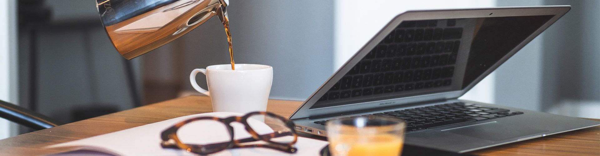 Bord med dator, glasögon och dryck