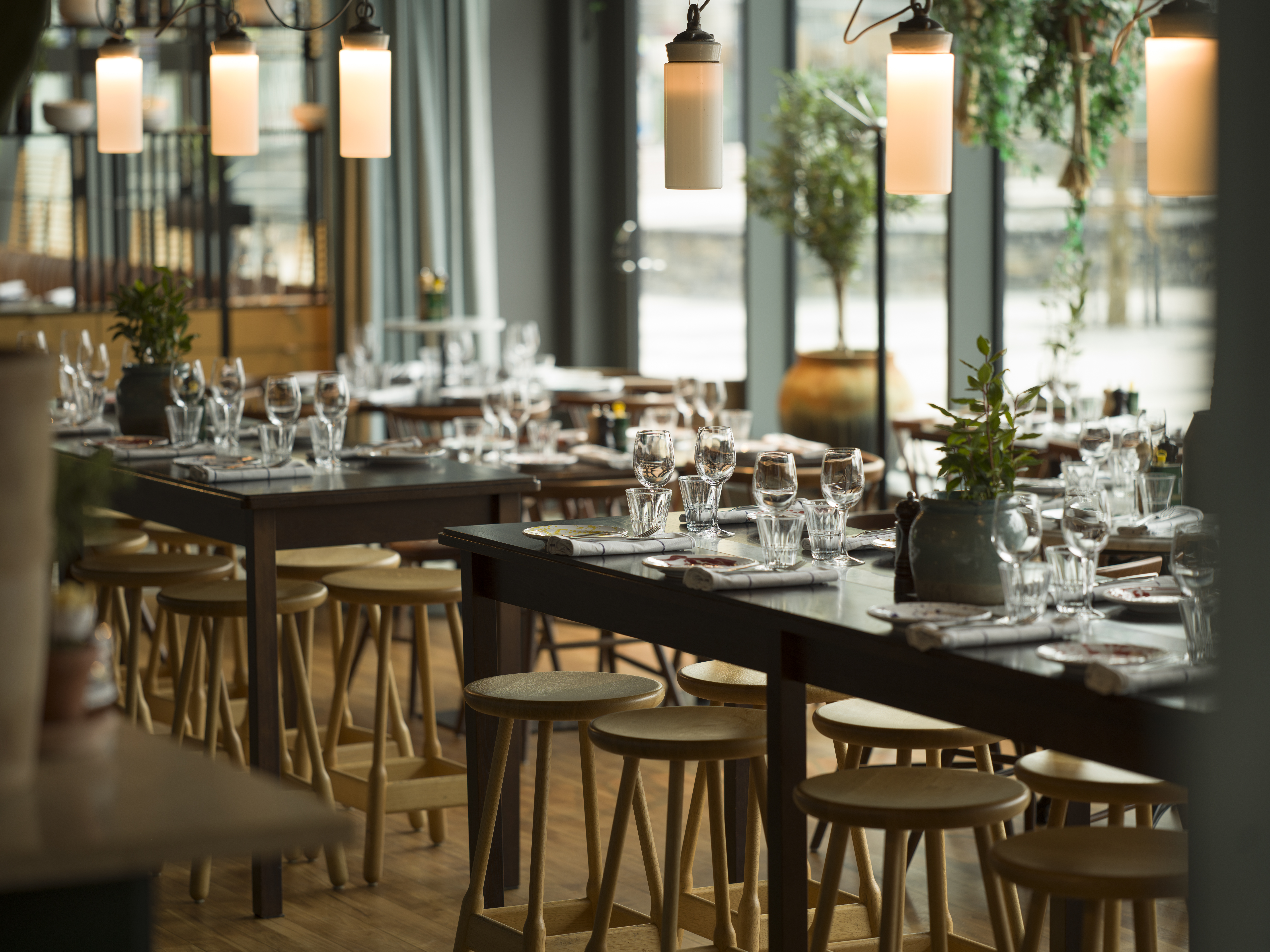 Restaurang med modern inredning och stora fönster.
