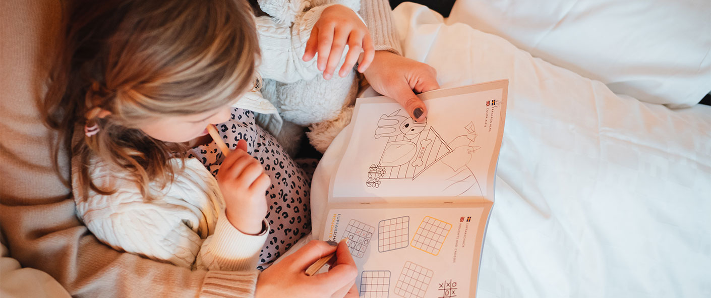 En mamma fyller i en barnbok med sin dotter