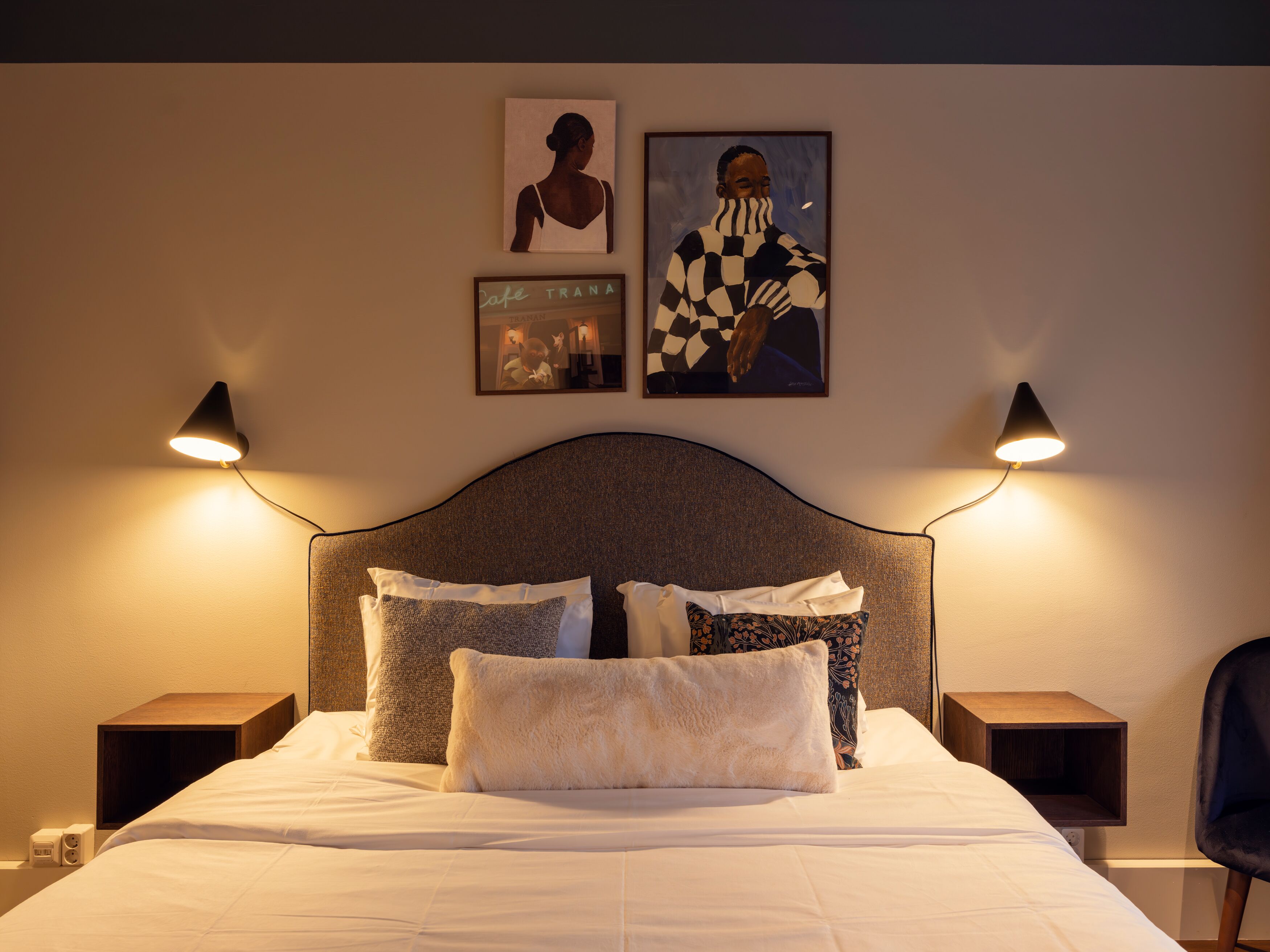 Ljust hotellrum med säng, stol och fönster