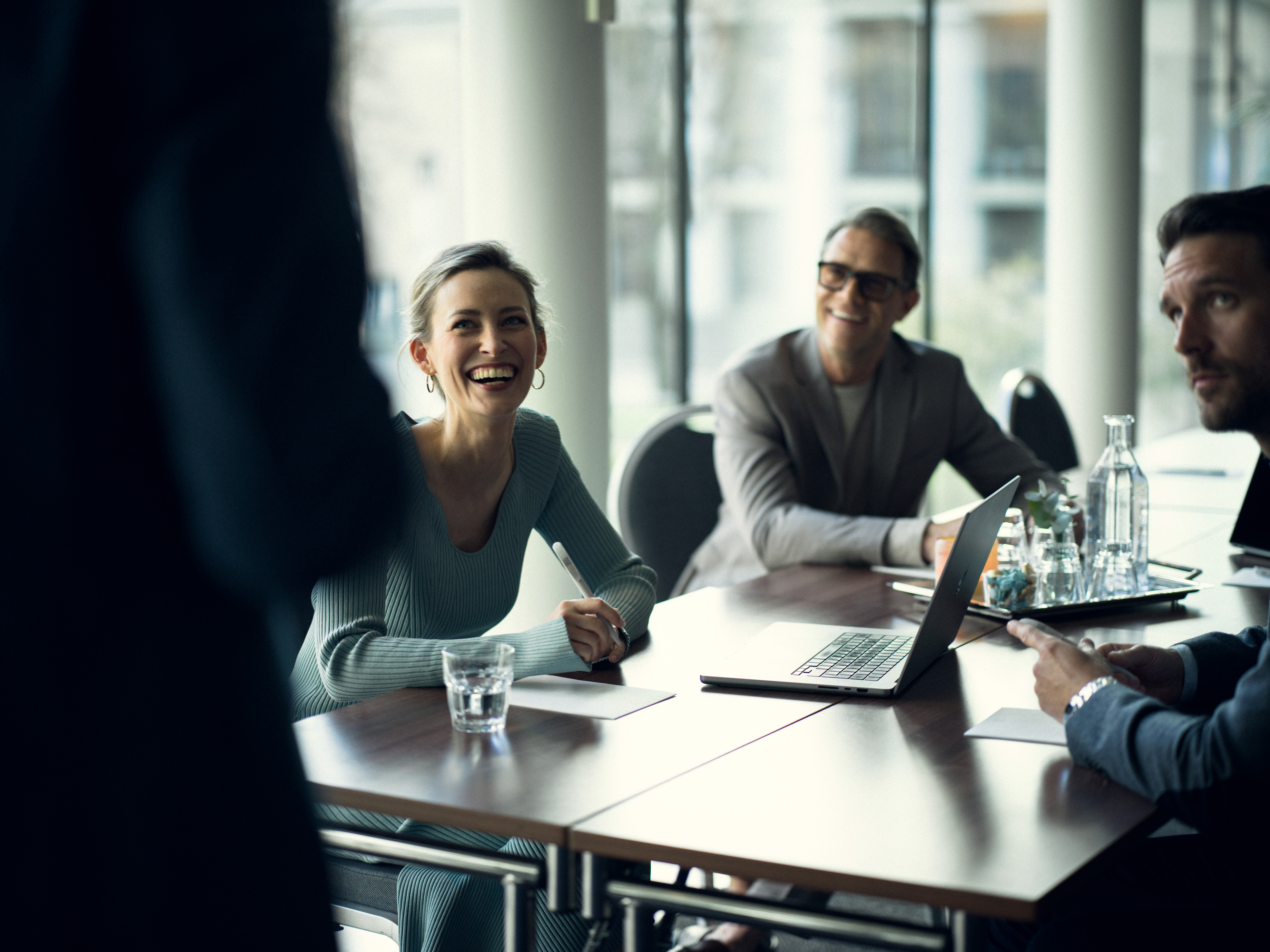 Personer som lutar sig över konferensbord med pennor i händerna