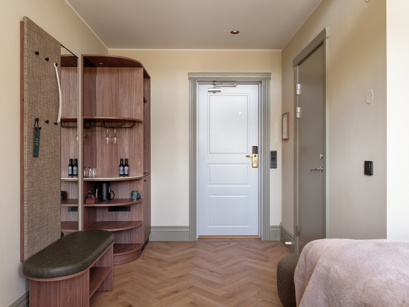 Modern hotellrum med garderob och dörr