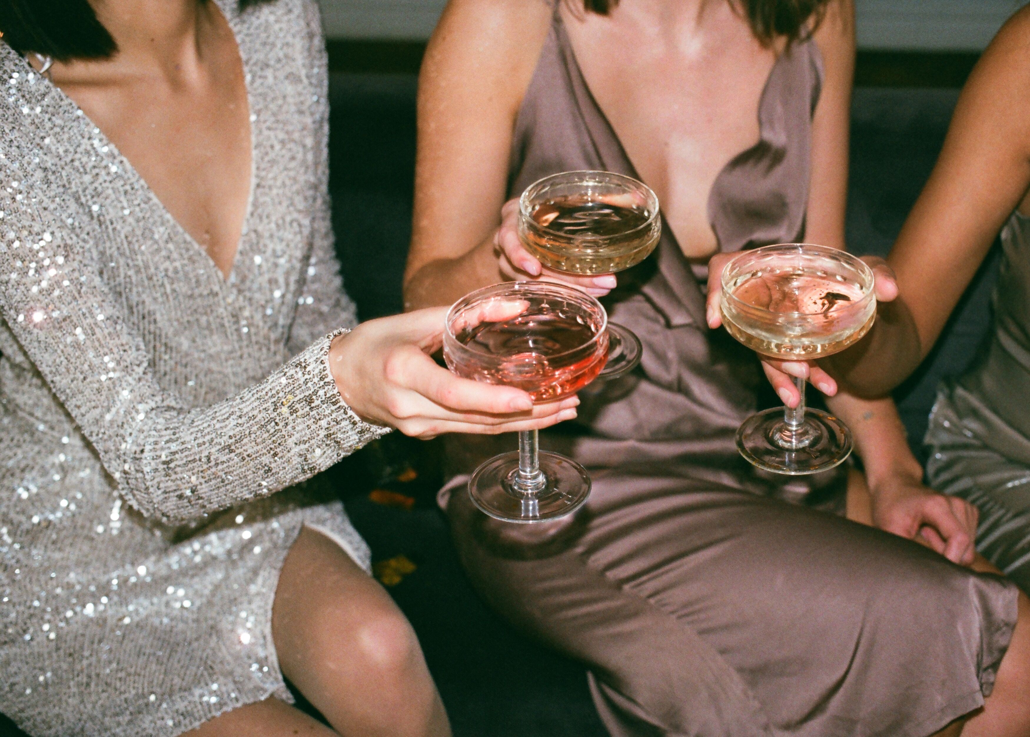Tre kvinnor skålar med champagneglas