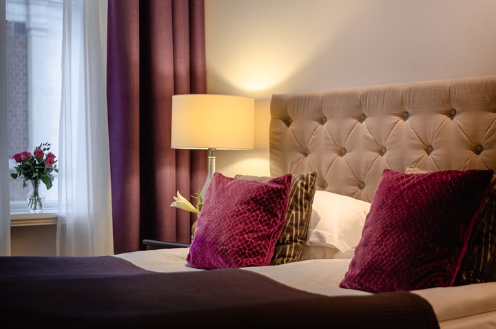 Mysigt hotellrum med säng och lampor