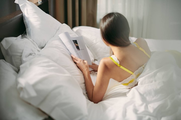 Person som ligger i säng utomhus.