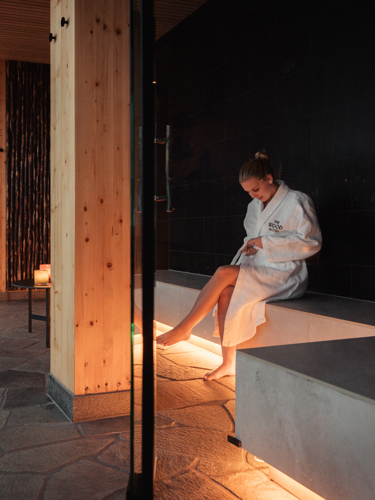 Woman in bathrobe sitting in sauna