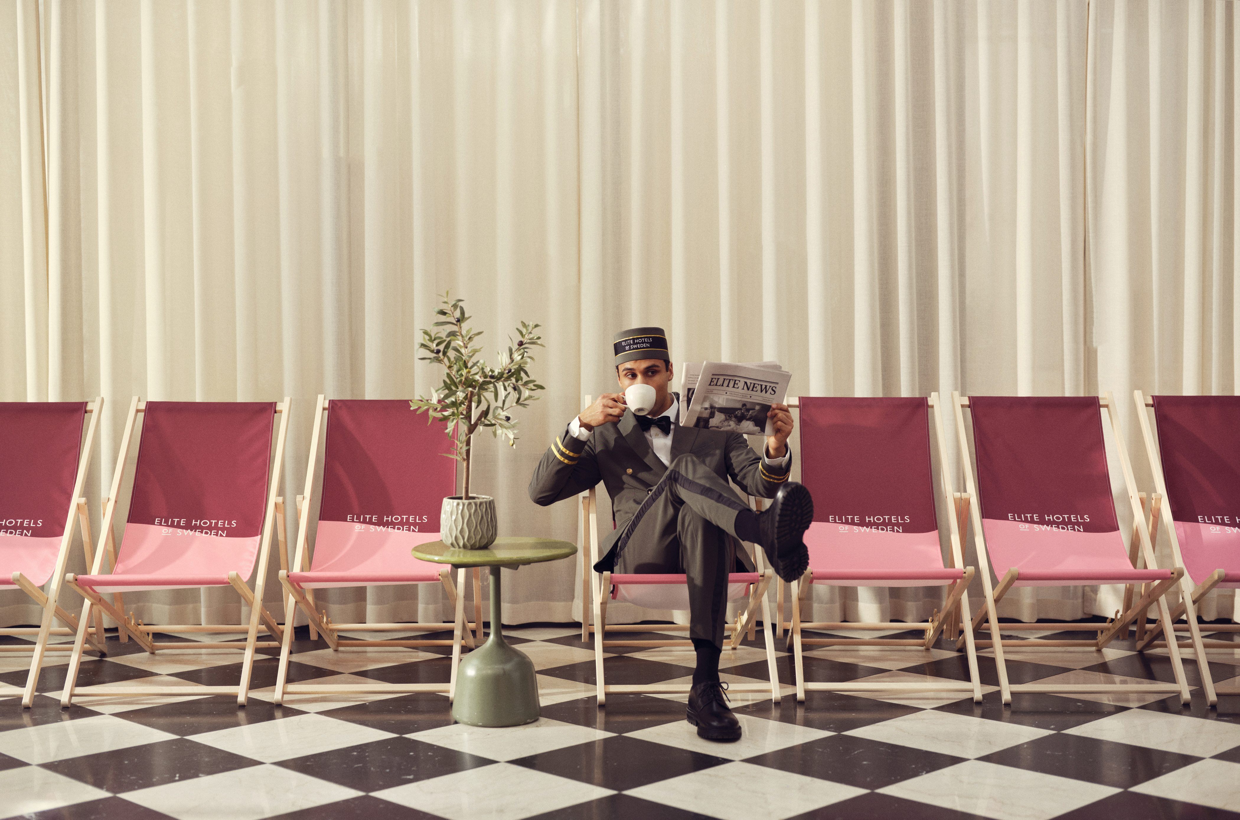 Group posing in winter attire with skis and sled indoors