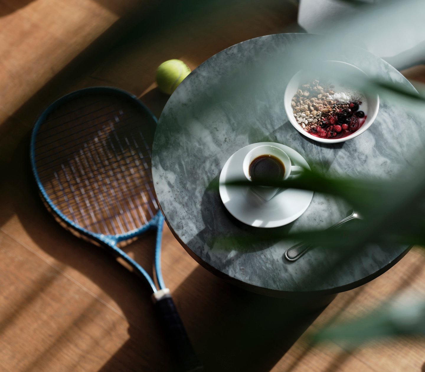 Bord med kaffe och tennisracket på golvet