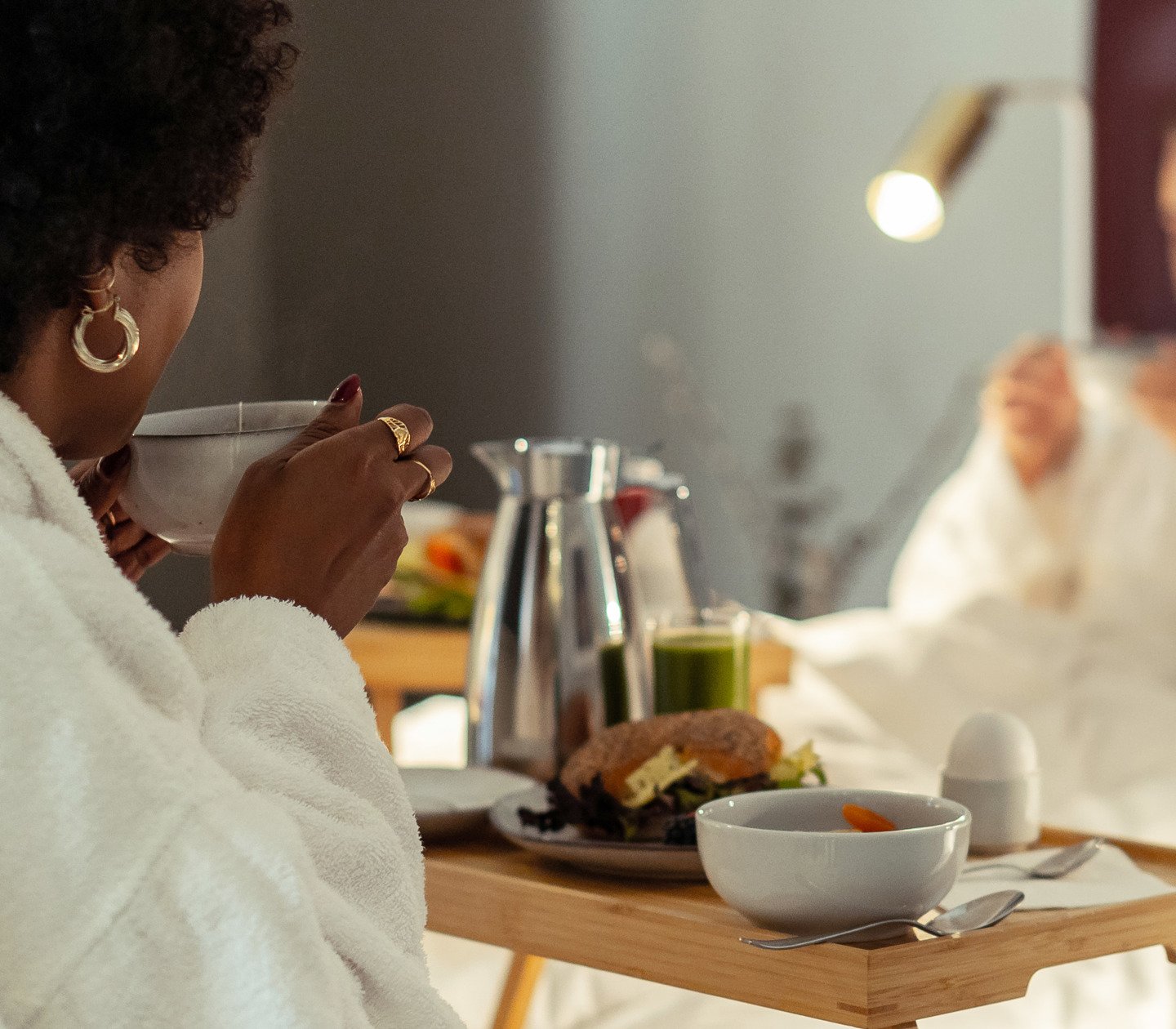 Women in a hotel bed with breakfast tray