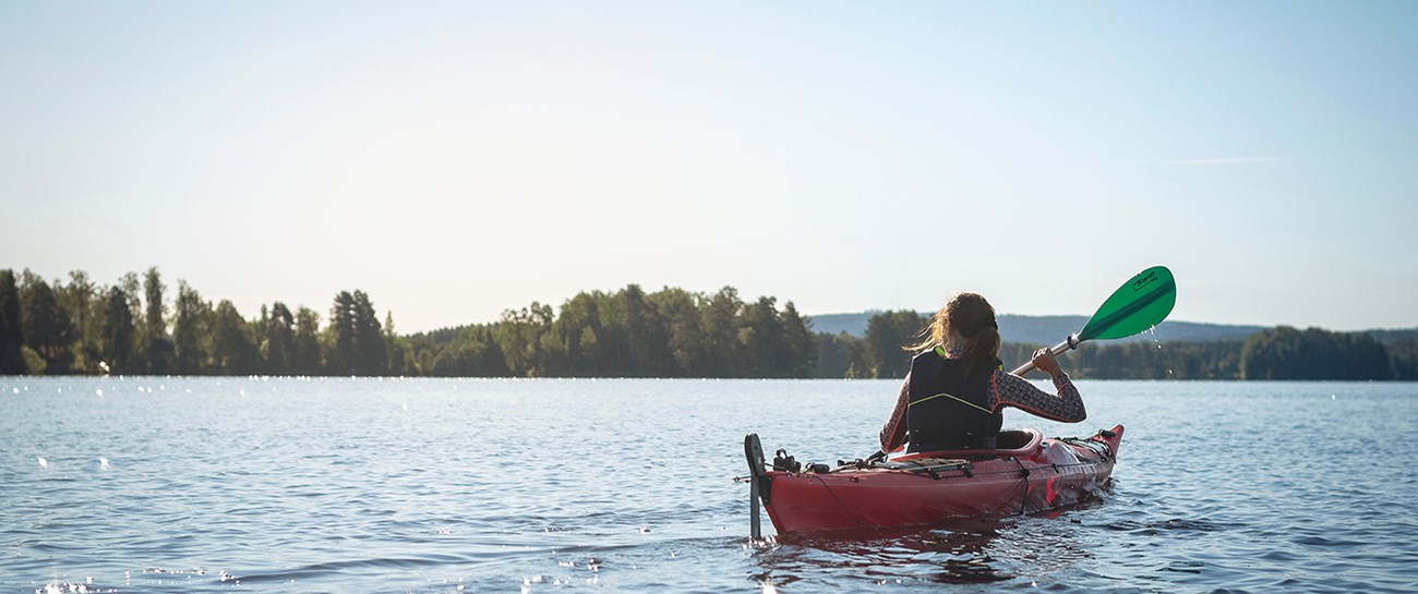 Kvinna i kajak på sommaren