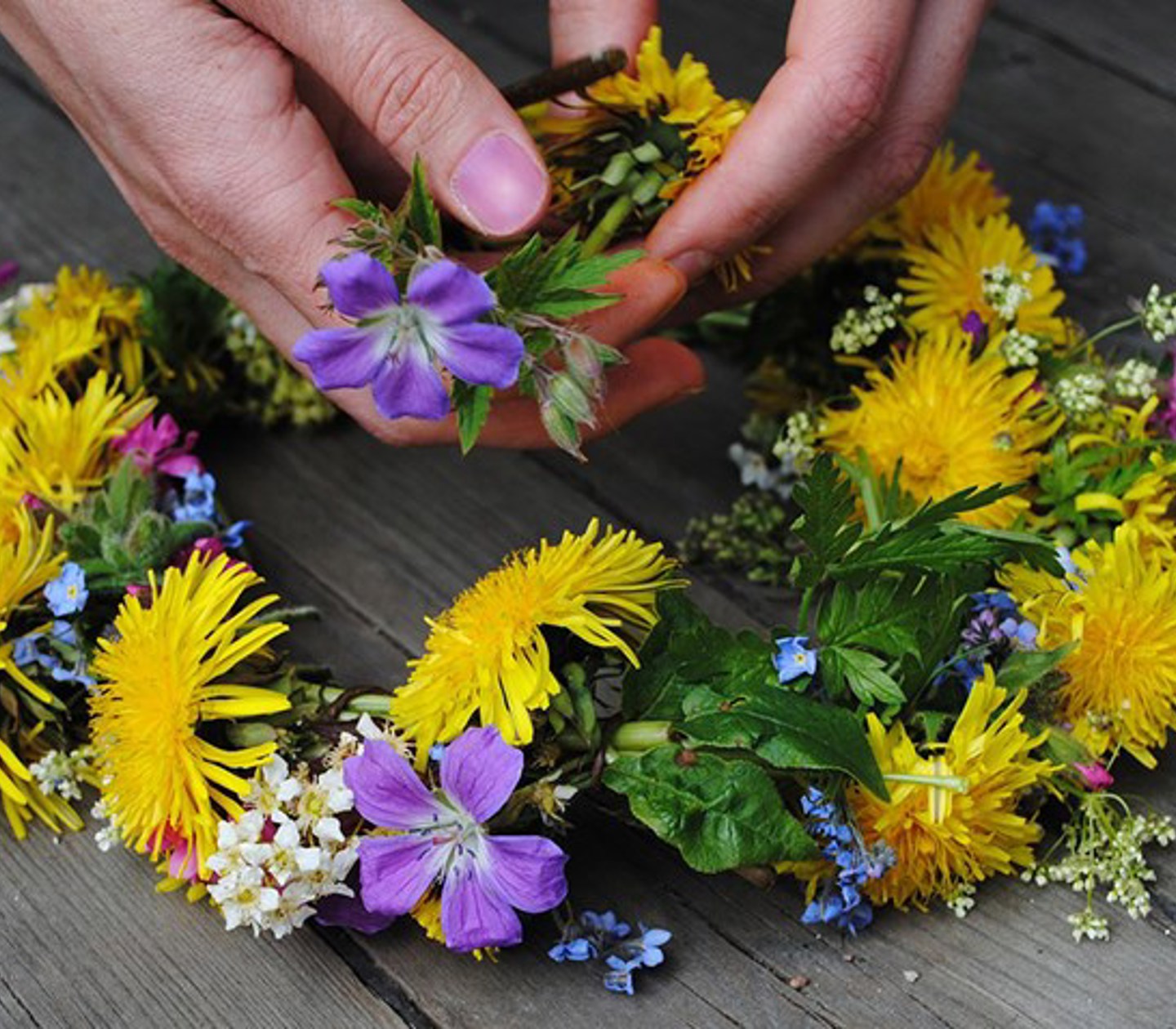 Hands assembling a midsummer wreath