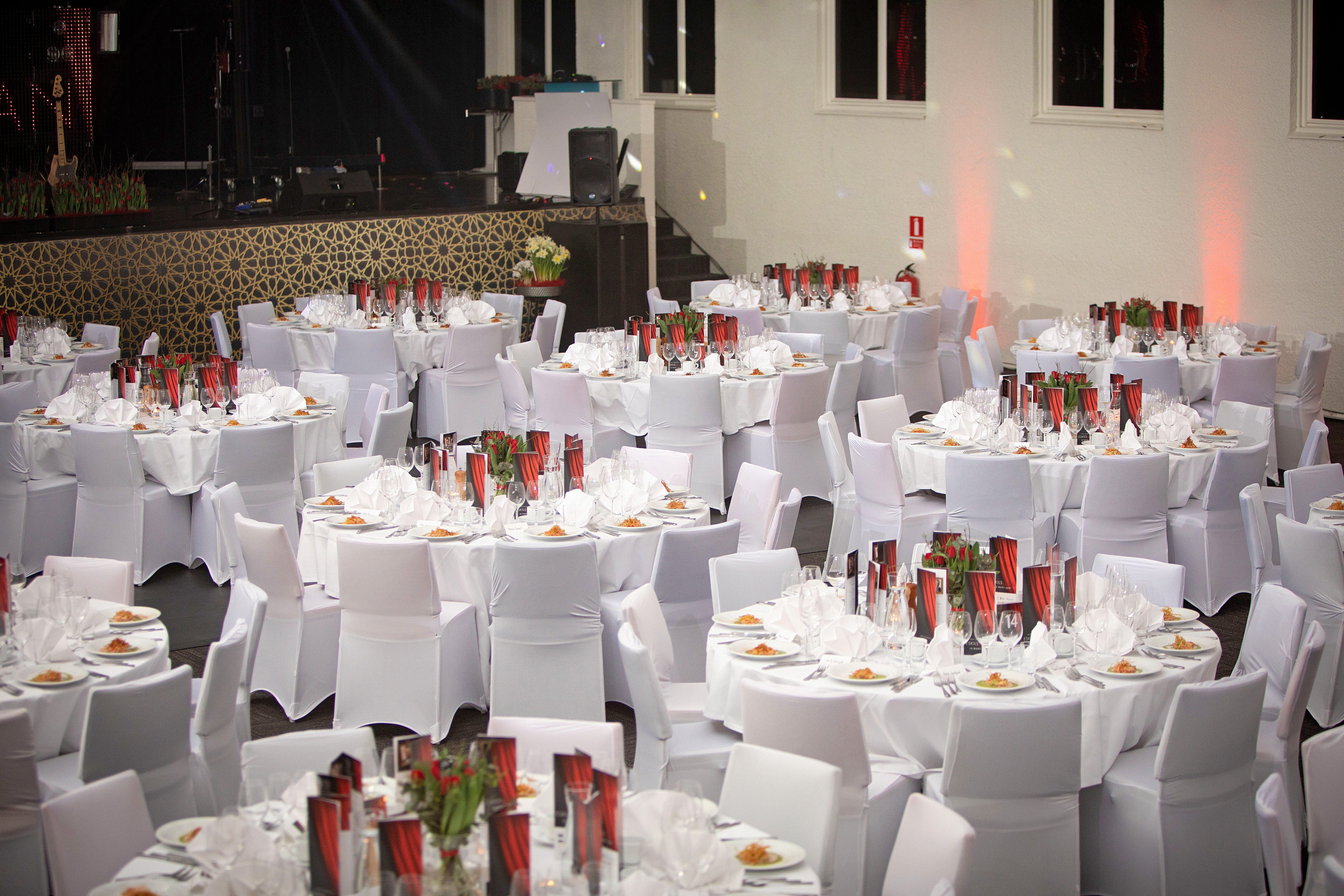 Runda bord med vita dukar fint dukade i konferensrum 