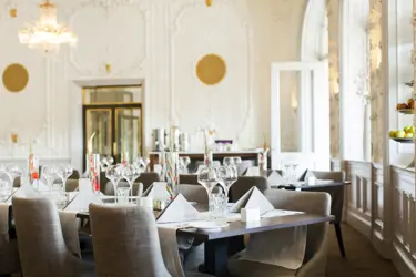 Elegant restaurang med dukade bord och ljusa inredningsdetaljer