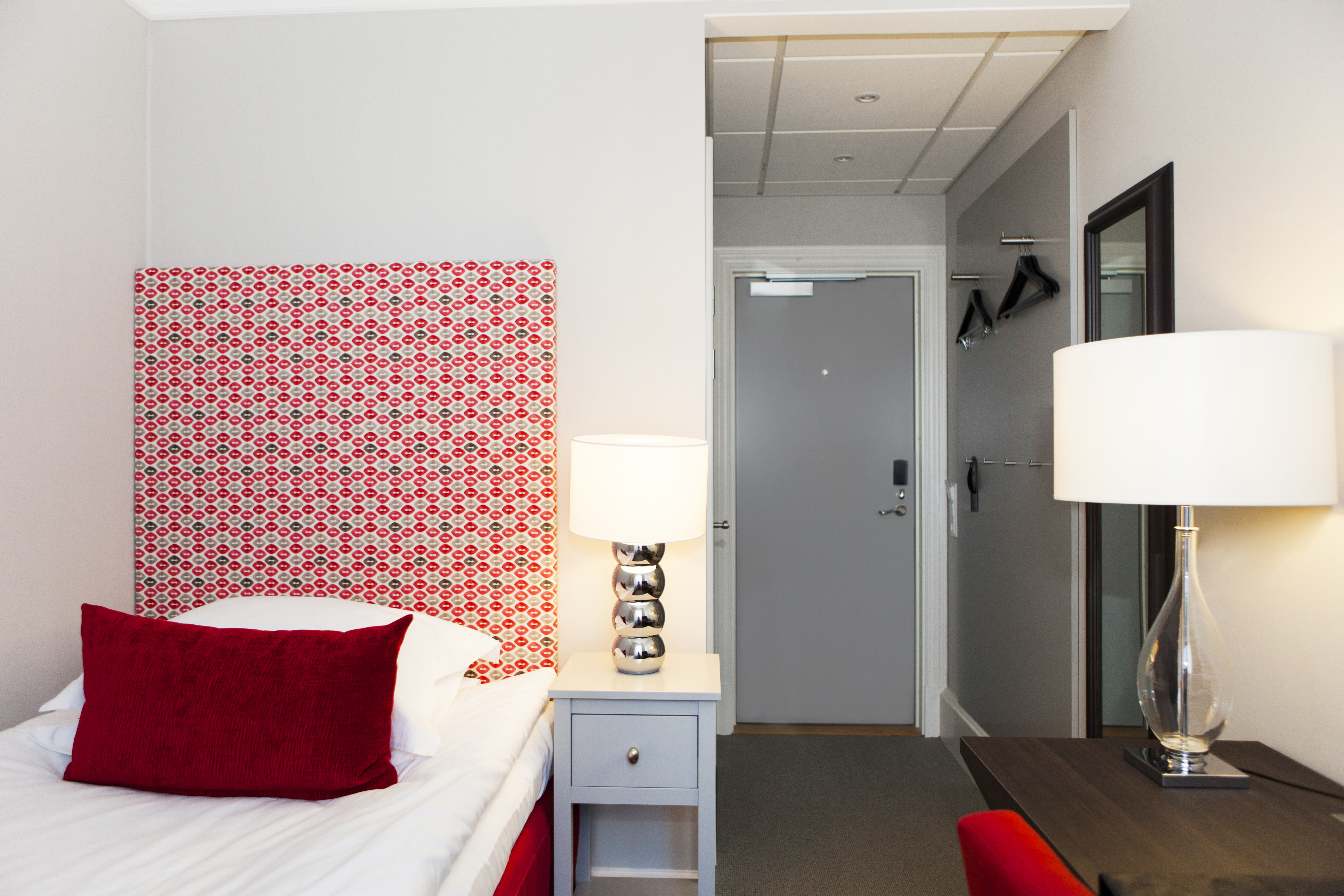 Hotel room with single bed and two table lamps