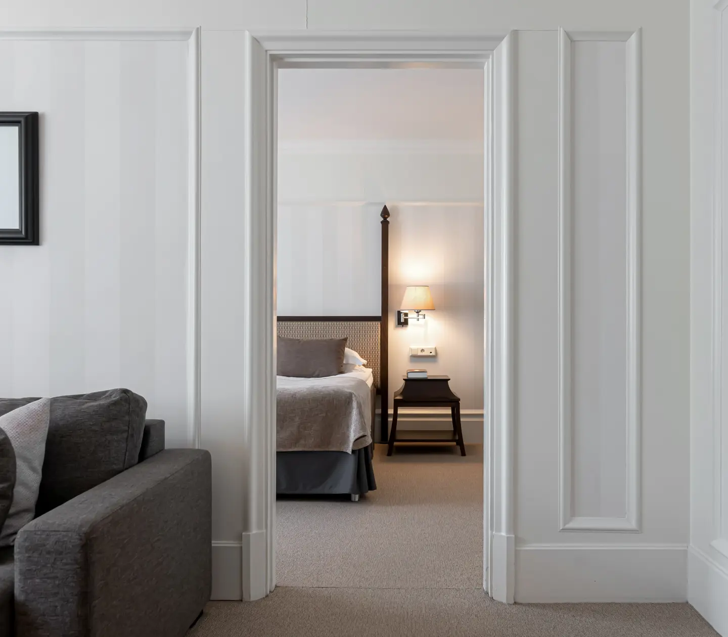 Suite with two rooms with bed, sofa and mirror