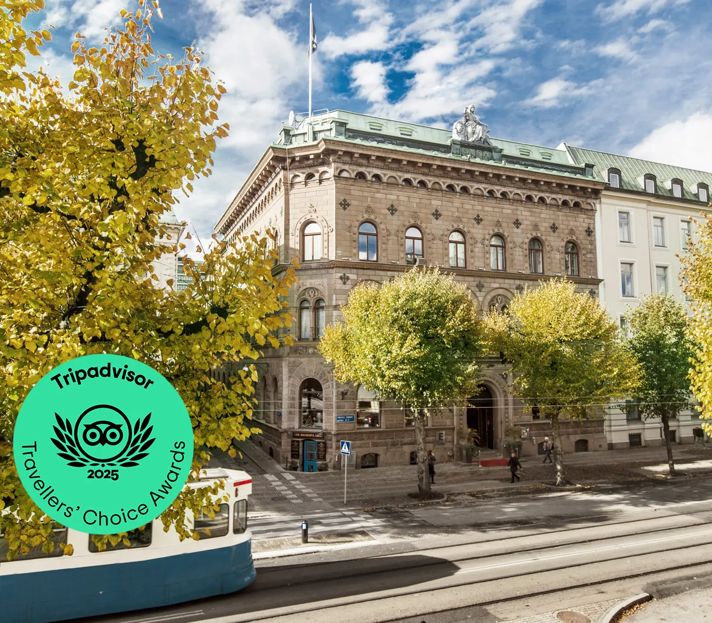 Nice facade of Elite Plaza Hotel in Gothenburg with trees and tram in front