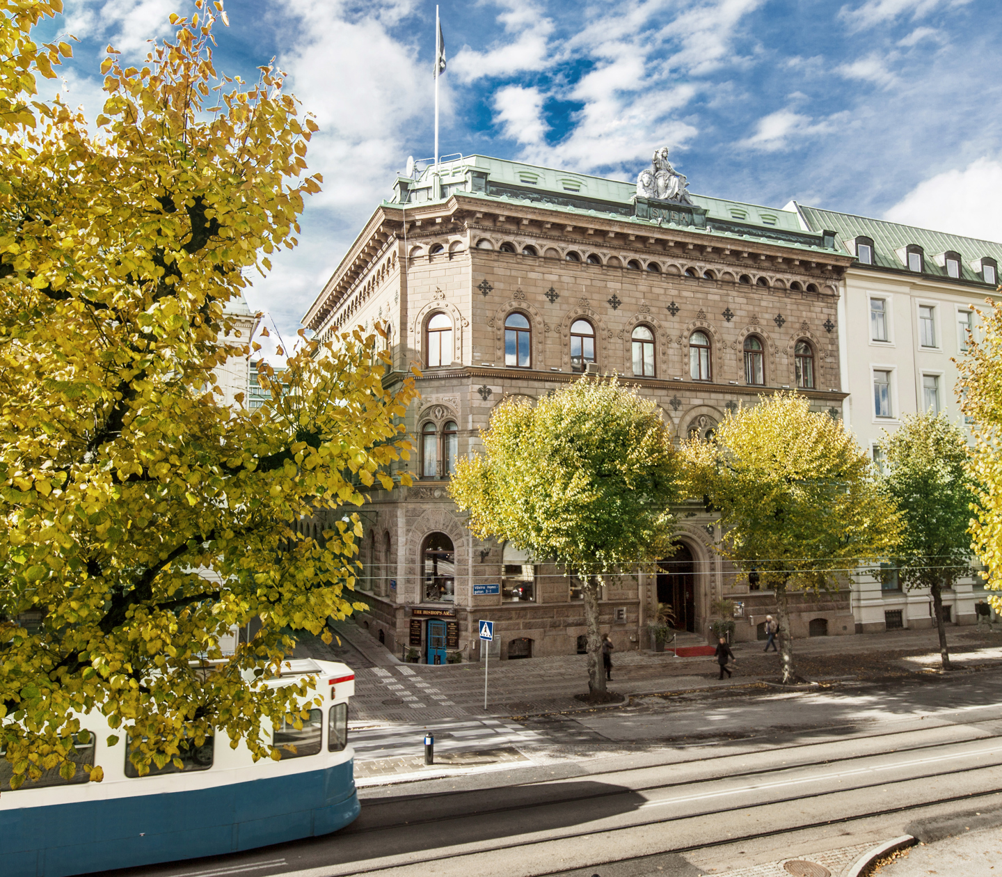 Nice facade of Elite Plaza Hotel in Gothenburg with trees and tram in front