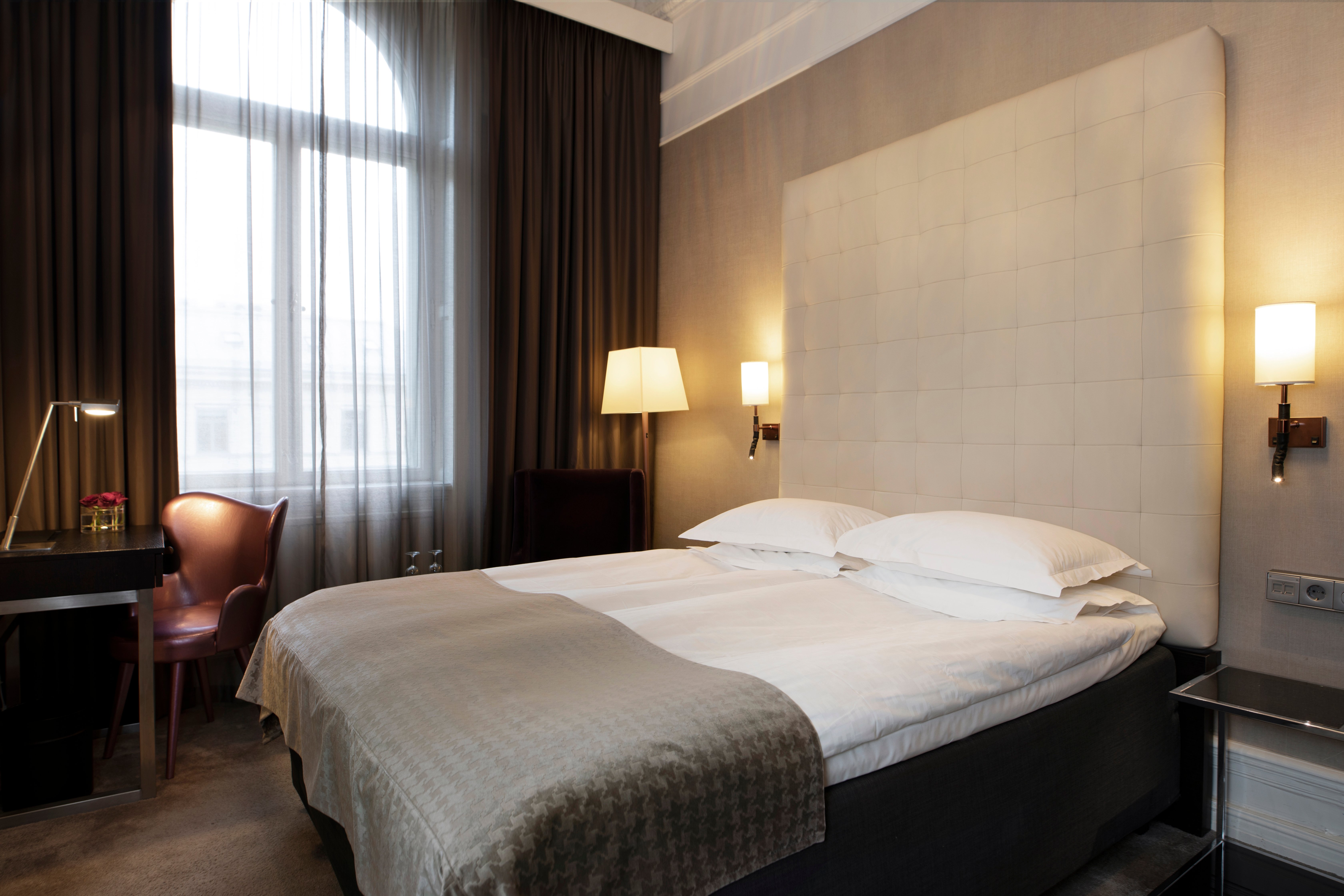 Hotel room with bed, large headboard and desk