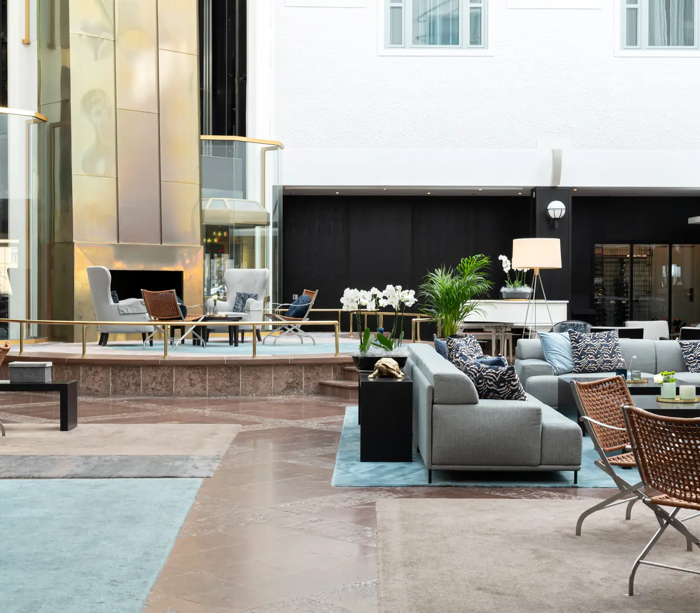 Ljus hotellobby med soffgrupper och växter