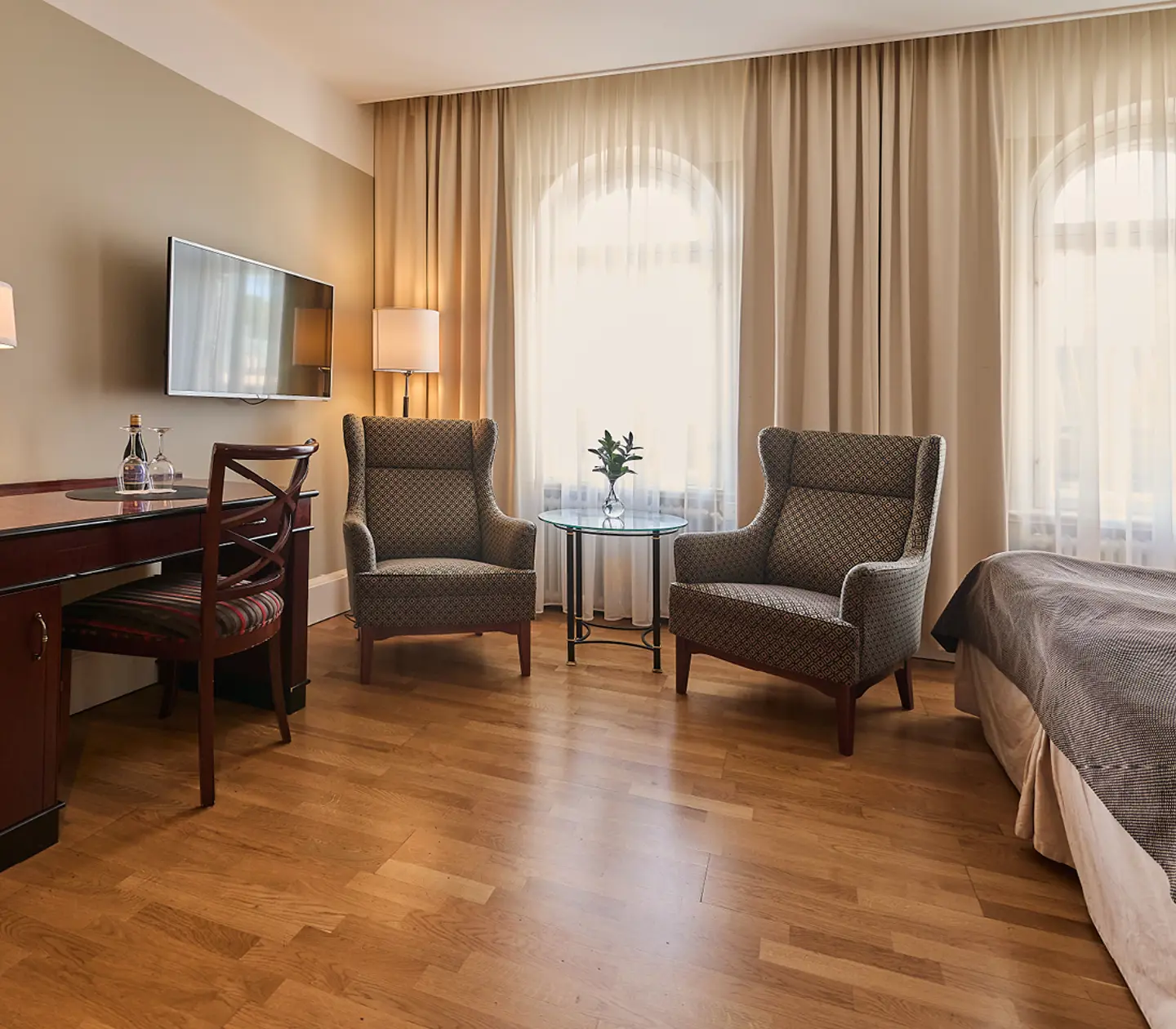 Hotel room with desk, armchair and curtains