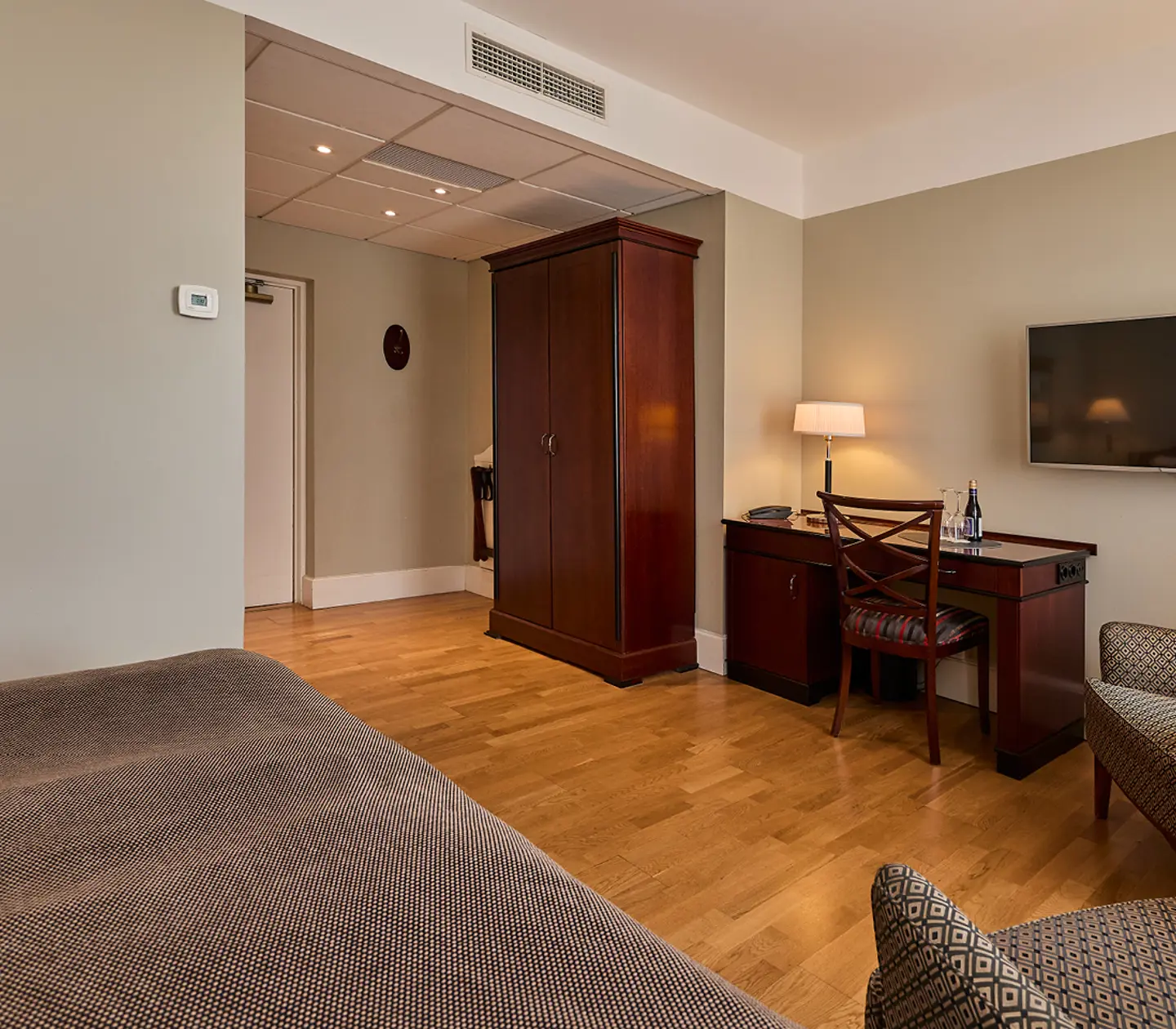 Hotel room with desk, armchair and TV