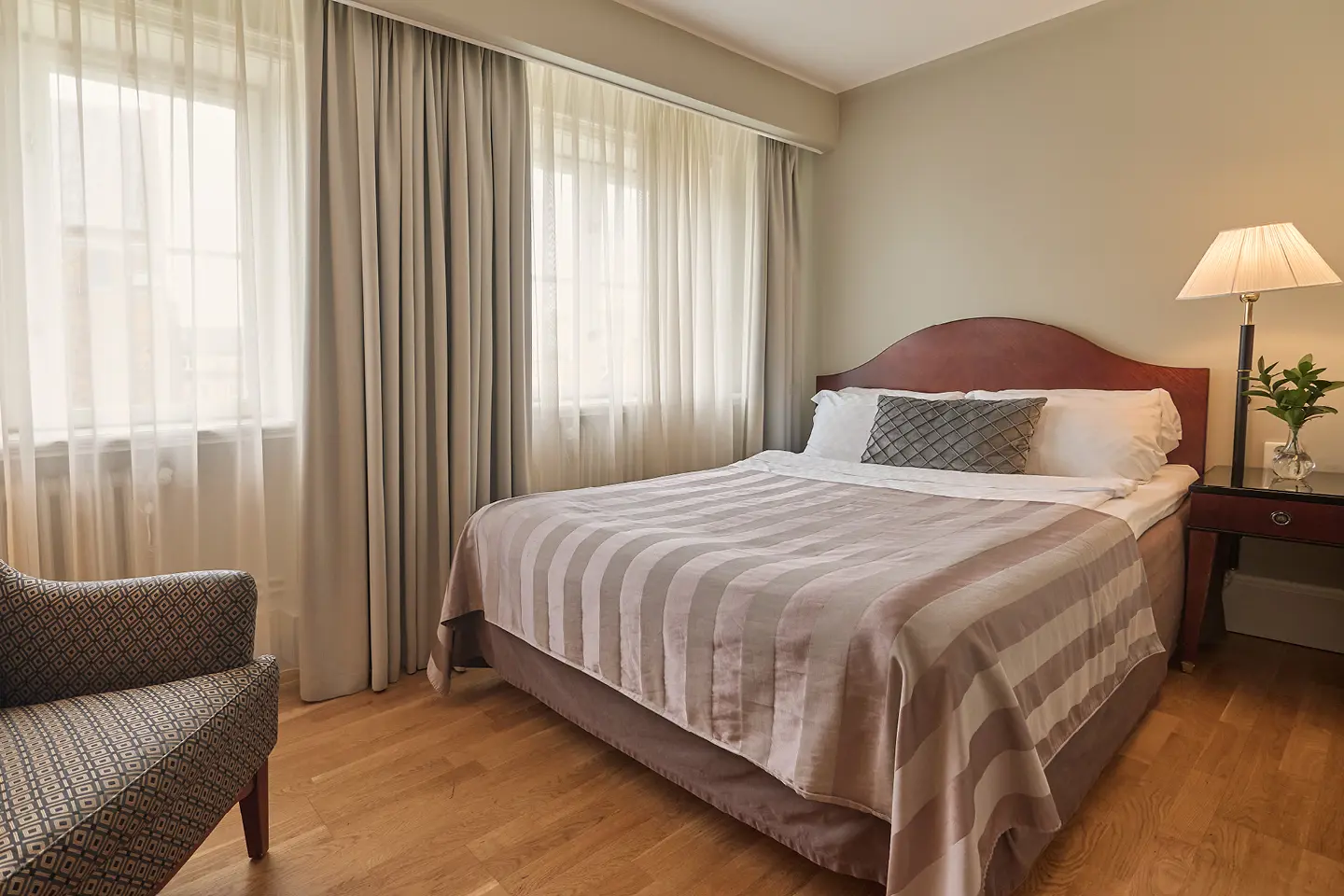 Hotel room with double bed, red headboard and desk