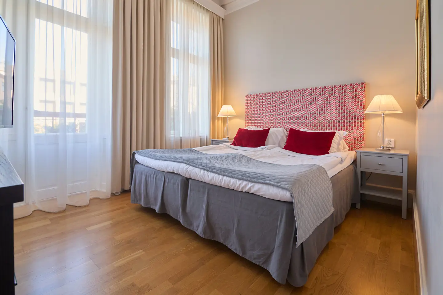 Suite with mirror, seating area and green tiled stove