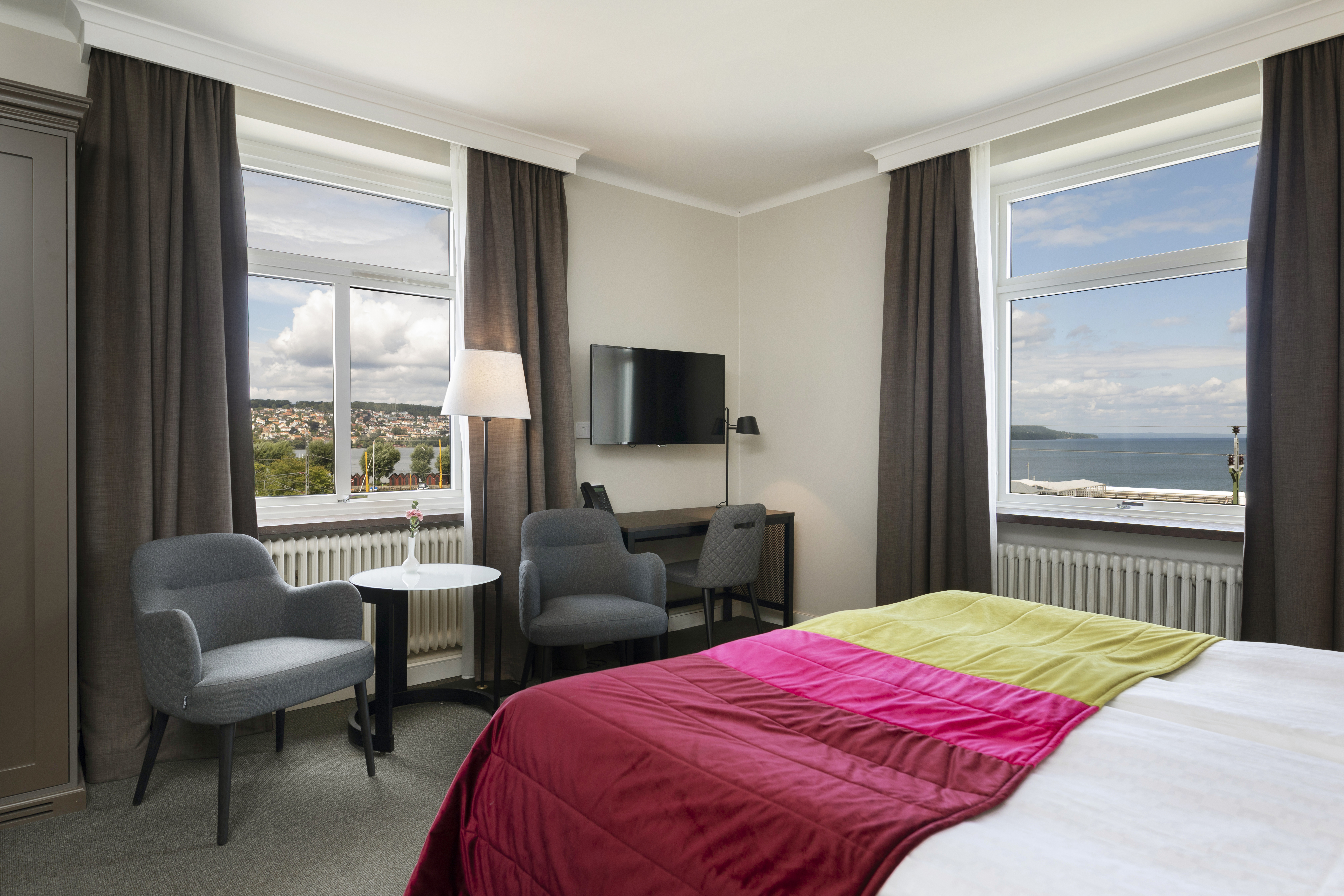 Hotel room with bed, armchairs and sea view