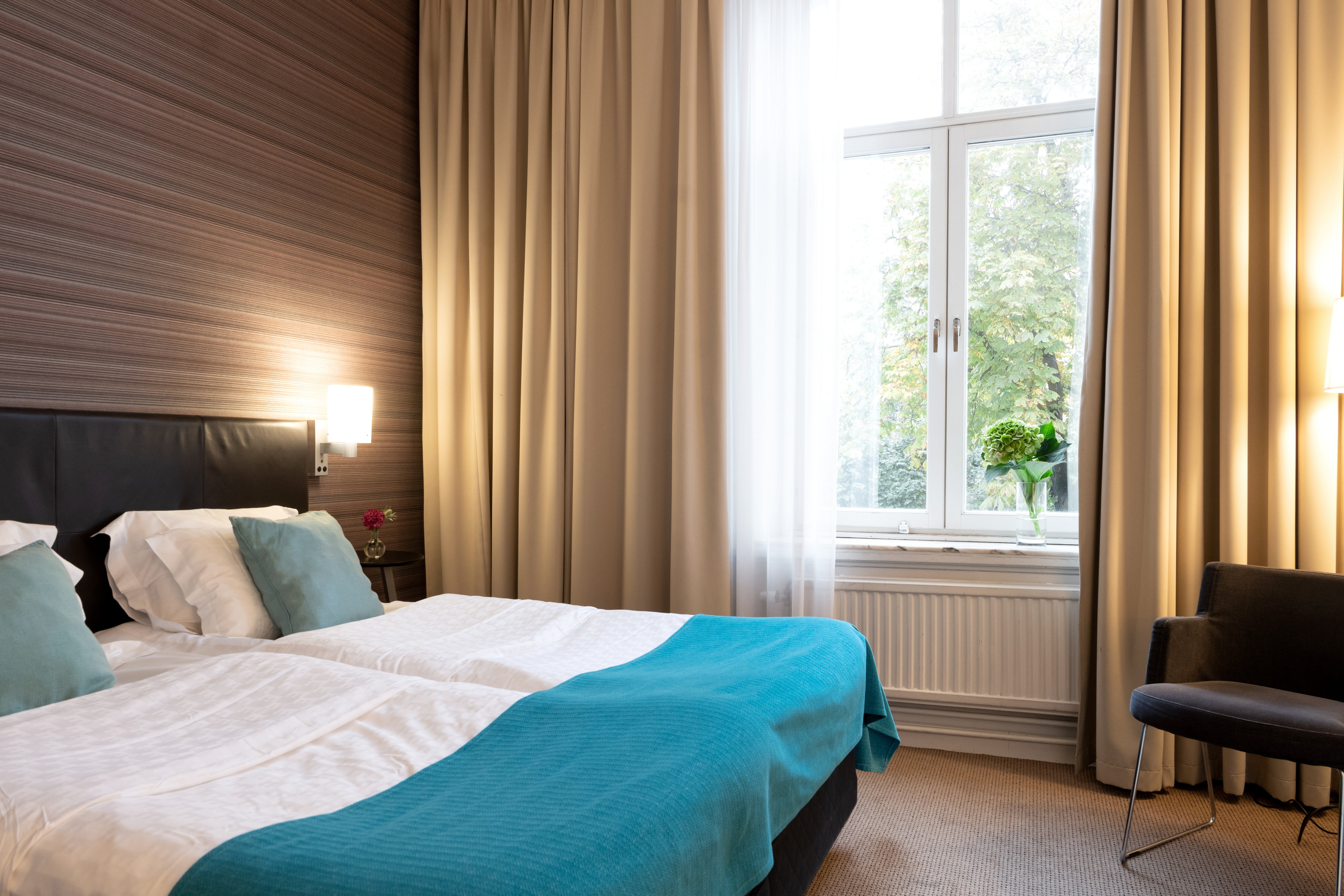 Hotel room with double bed, armchair and window