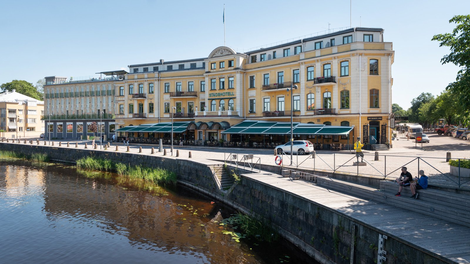 Pampiga gula fasaden av Elite Stadshotellet i Karlstad med Klarälven framför