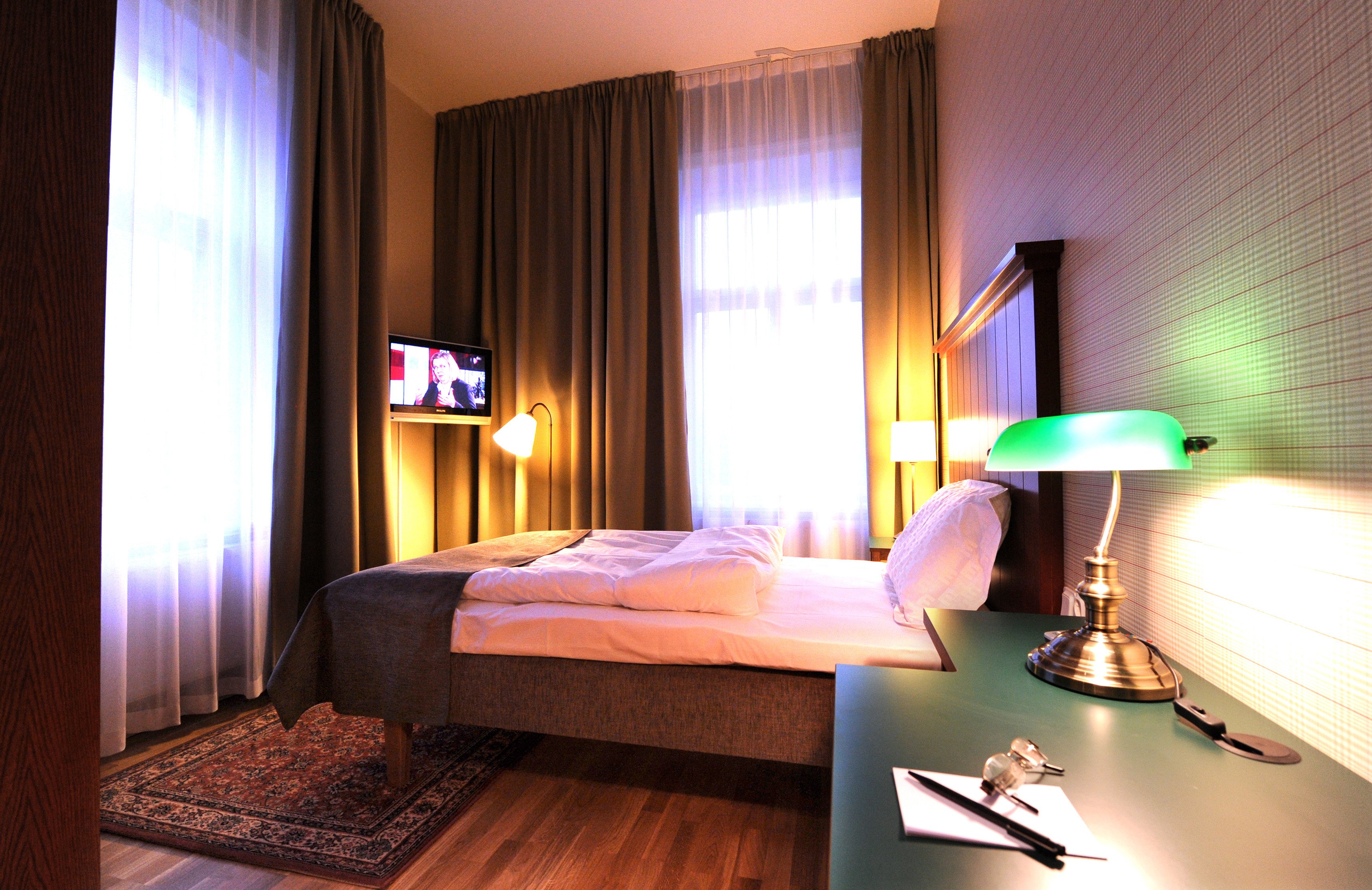 Hotel room with bed, large headboard and TV