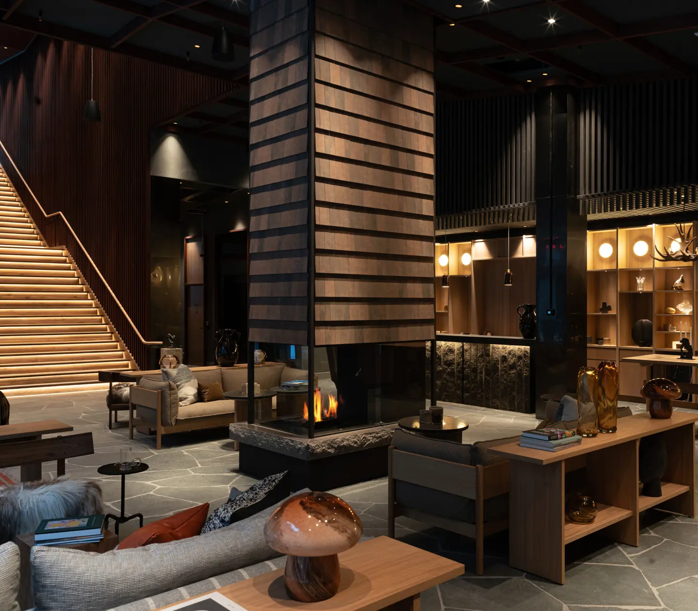 Lobby med receptionsdisk, stor brasa och sittplatser