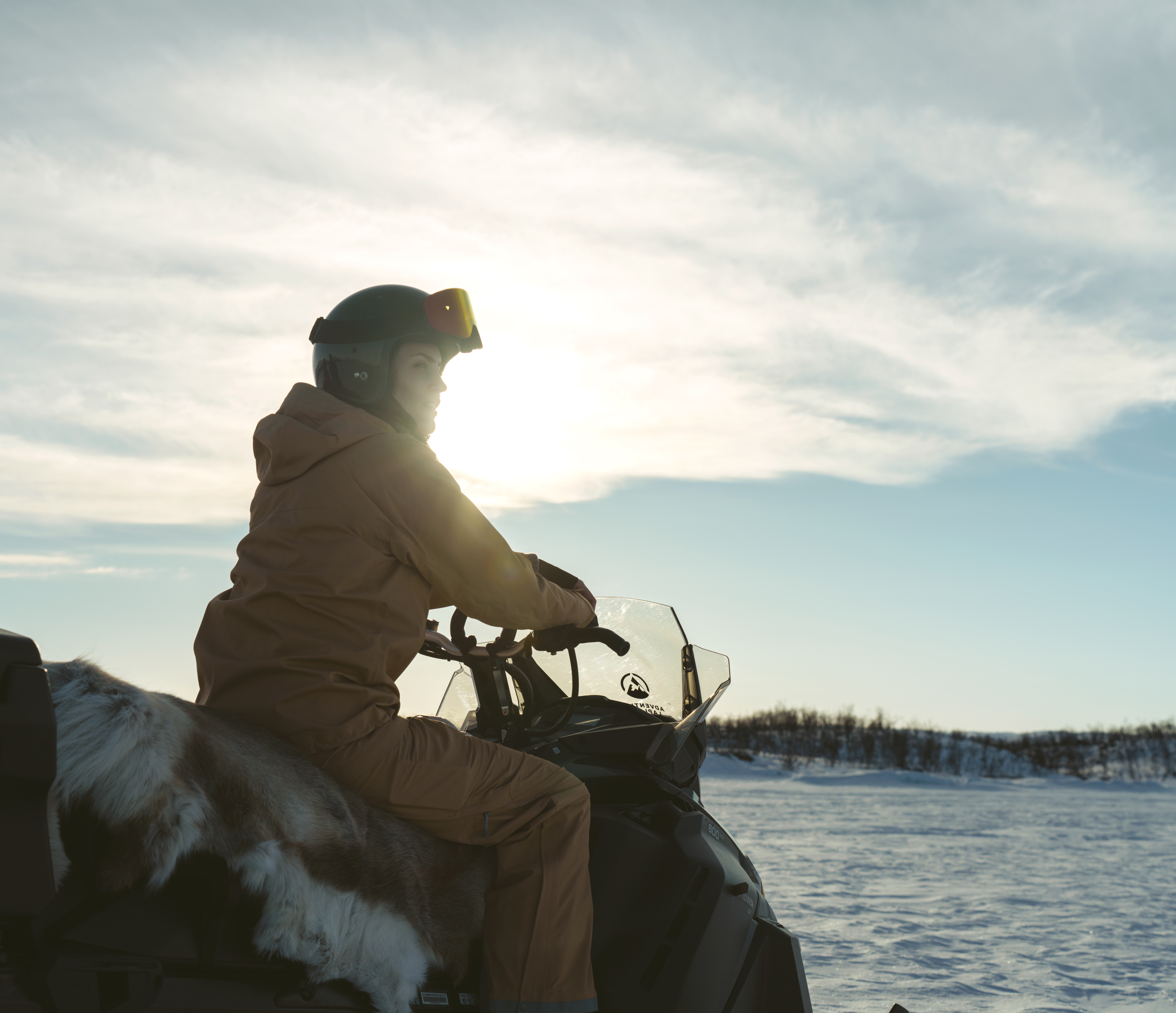Kvinna som sitter på en snöskoter
