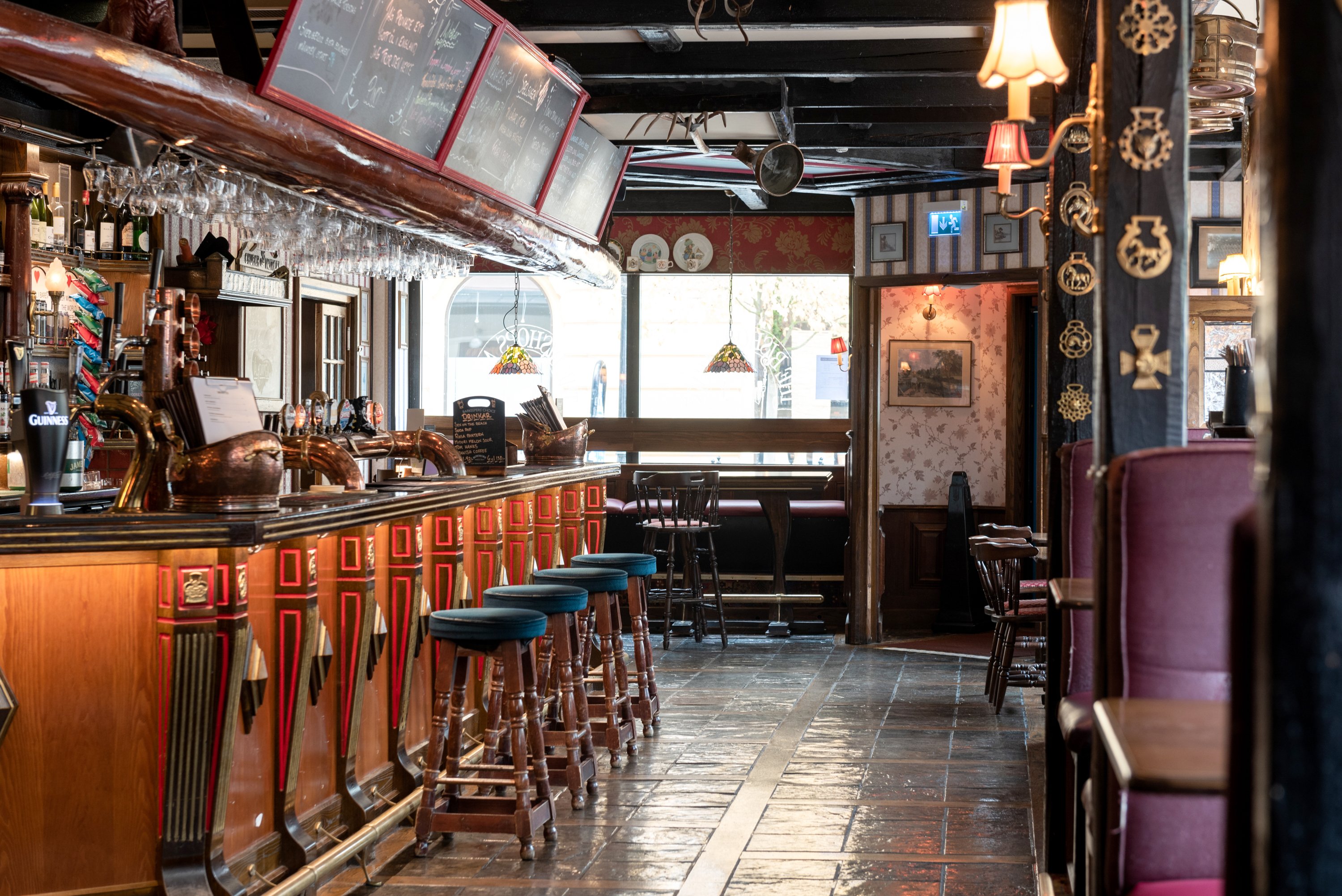 Pub environment with seating, bar and menus on blackboards